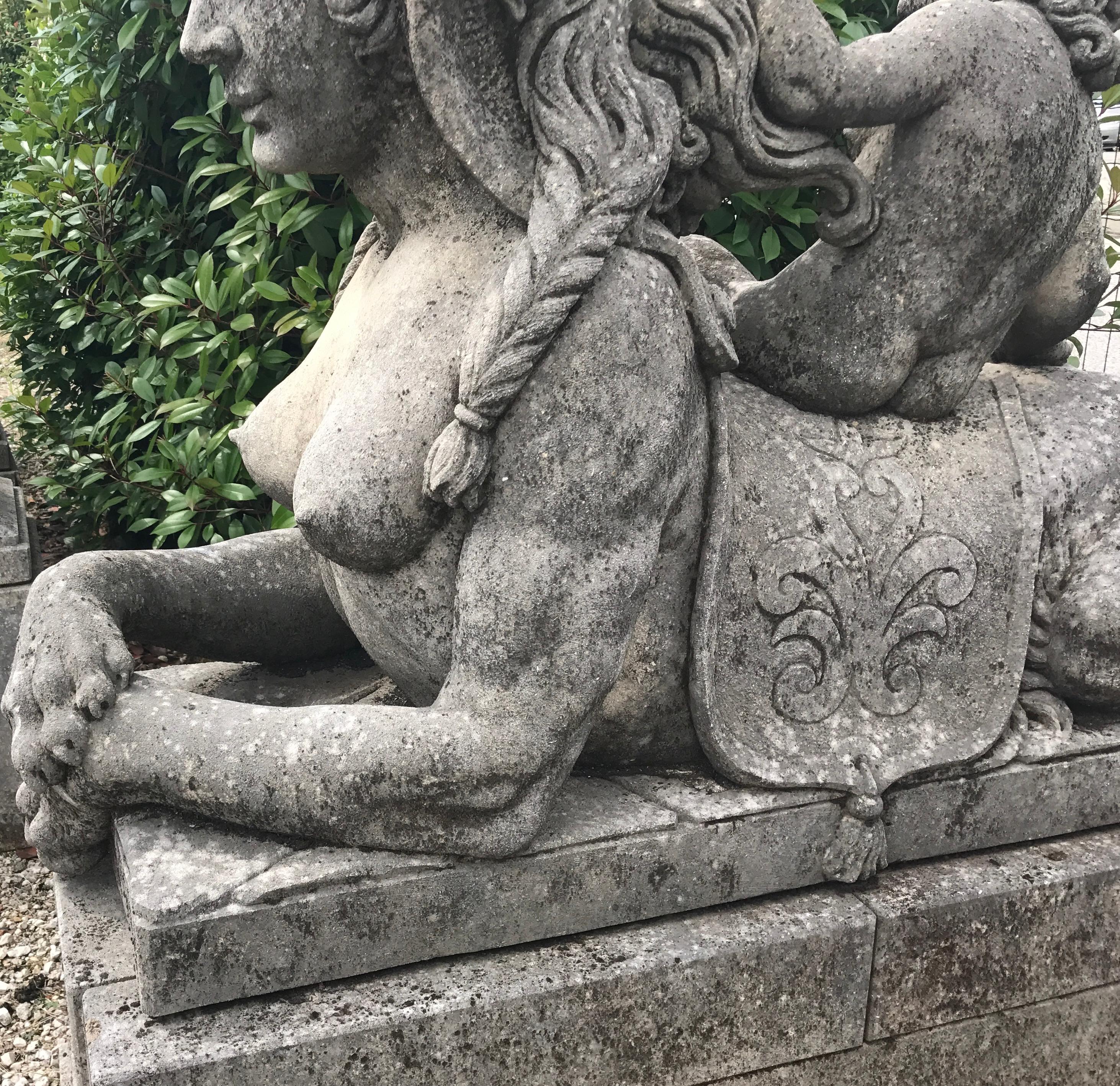Dieses Paar mythischer Sphinx-Damen ist als Wächter des Eingangsbereichs konzipiert und zeigt den Kopf und die Brust einer klassizistischen Frau sowie den Körper eines liegenden Löwen auf einem rechteckigen Steinsockel. Sehr guter Zustand mit leicht