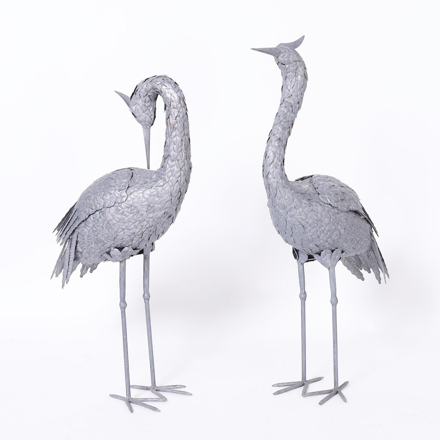 Standup pair of life size mid century cranes hand crafted in metal, each with its own familiar stance and chic raw metal finish.

Left H: 29 W: 17 D: 7
Right H: 32 W: 20 D: 7