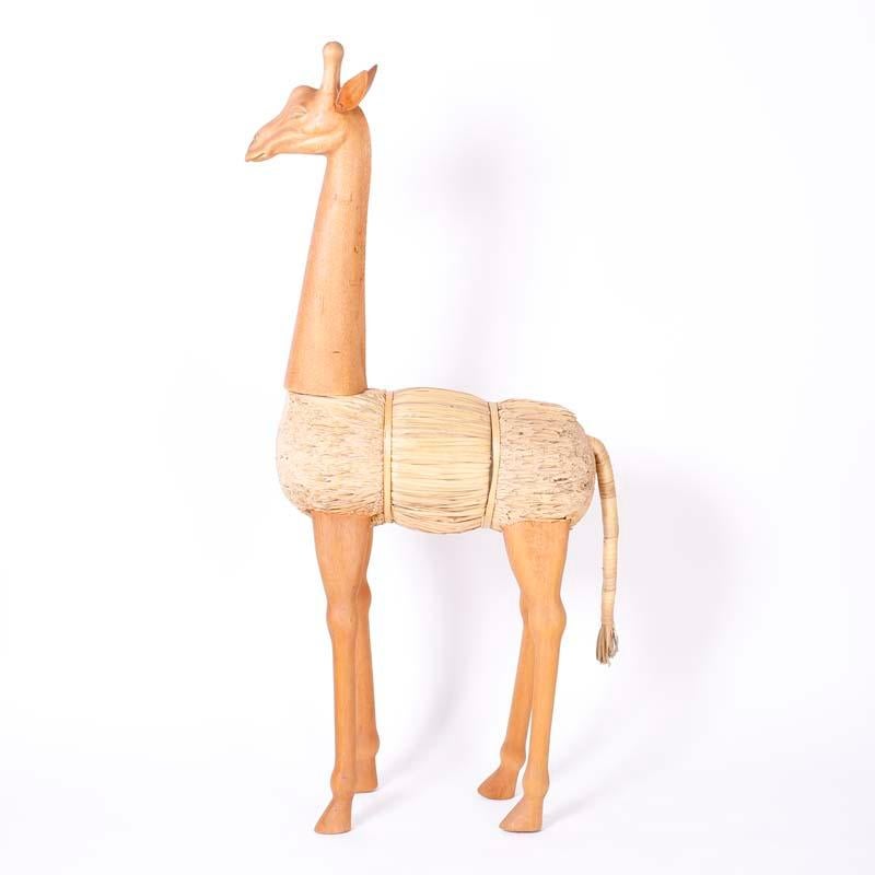 Paire exceptionnelle de girafes du milieu du siècle dernier, l'une debout et l'autre en train de brouter, dont la construction unique est faite de faisceaux de roseaux rasés et dont la tête, le cou et les jambes sont en bois sculpté.

Girafe debout