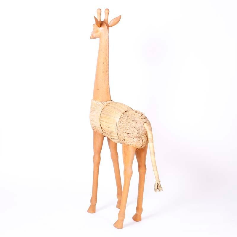 Stand out pair of mid century giraffes one standing and one grazing with a unique construction of shaved reed bundles and having carved wood heads, necks, and legs.

Standing Giraffe: H: 60 W: 28 D: 8
Grazing Giraffe: H: 34 W: 43 D: 9