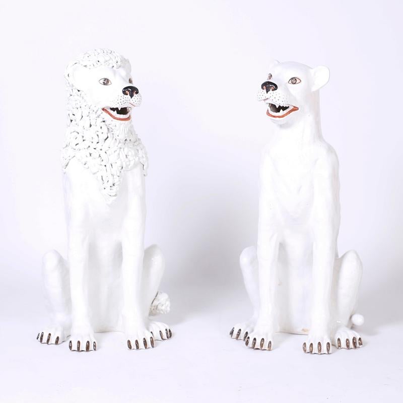 Whimsical pair of Italian midcentury terracotta male and female lions with a white glaze and painted details. Although hardly ferocious these seated big cats command attention with their unexpected benevolence and stark white palette.