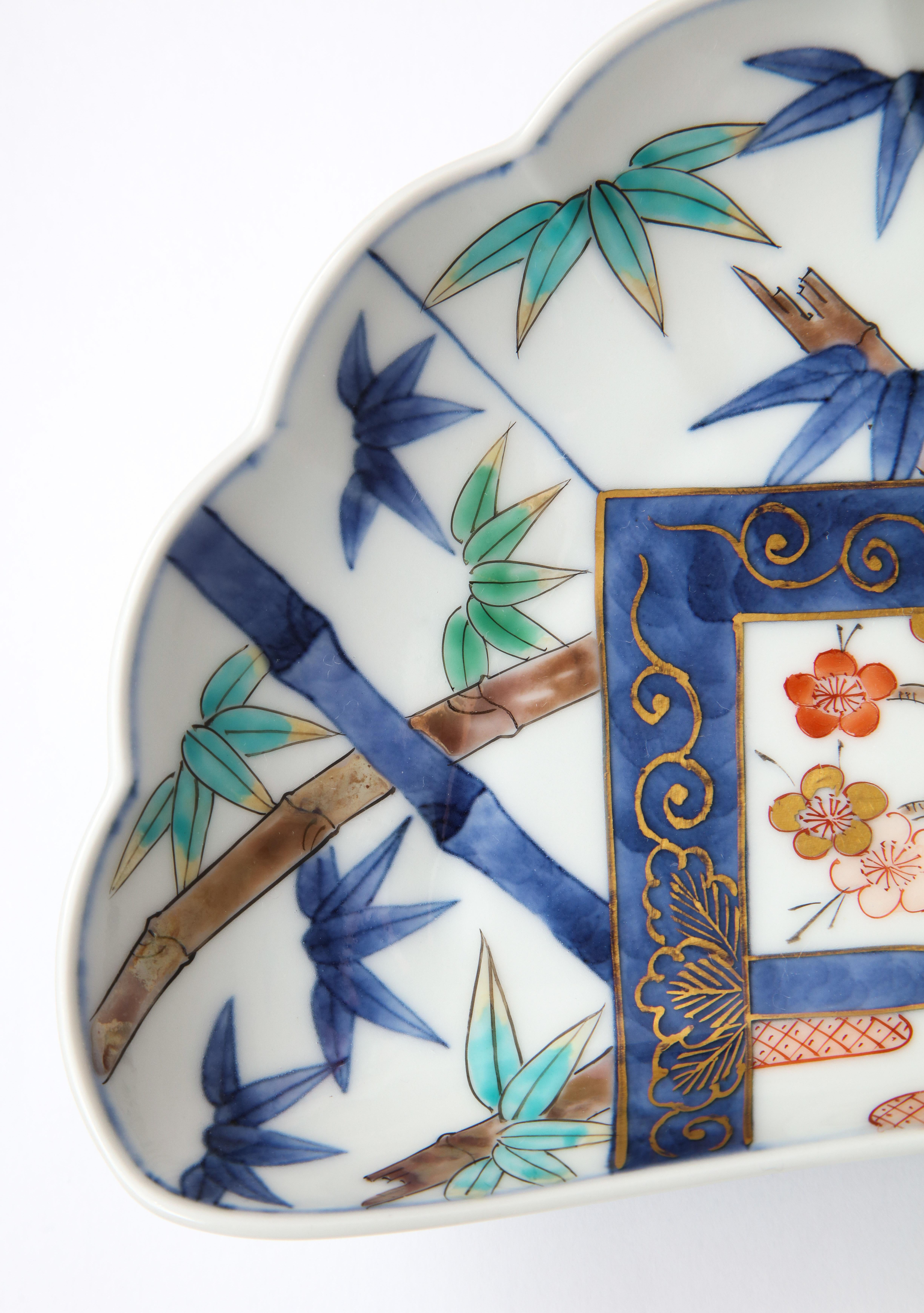 Gorgeous traditional Japanese porcelain plates in a very modern and chic style. The sea-shell shaped plate is decorated with incredibly bright and crisp details of leaves, sakura tree flowers, mountains and clouds. Each plate has artist’s signature