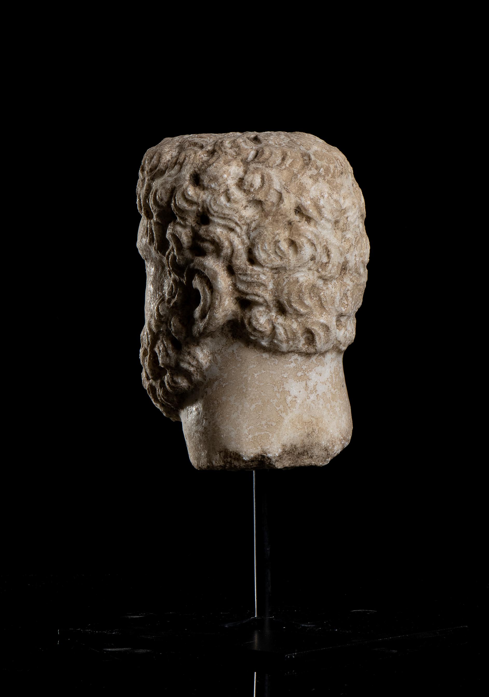 Ein aus weißem Marmor handgeschnitzter Kopf, der das Porträt des  Römischer Kaiser Caracalla, Rom 20. Jahrhundert .
Die Skulptur steht auf einem quadratischen Sockel aus schwarzem Metall mit einer zentralen Stecknadel und stellt ein detailliertes