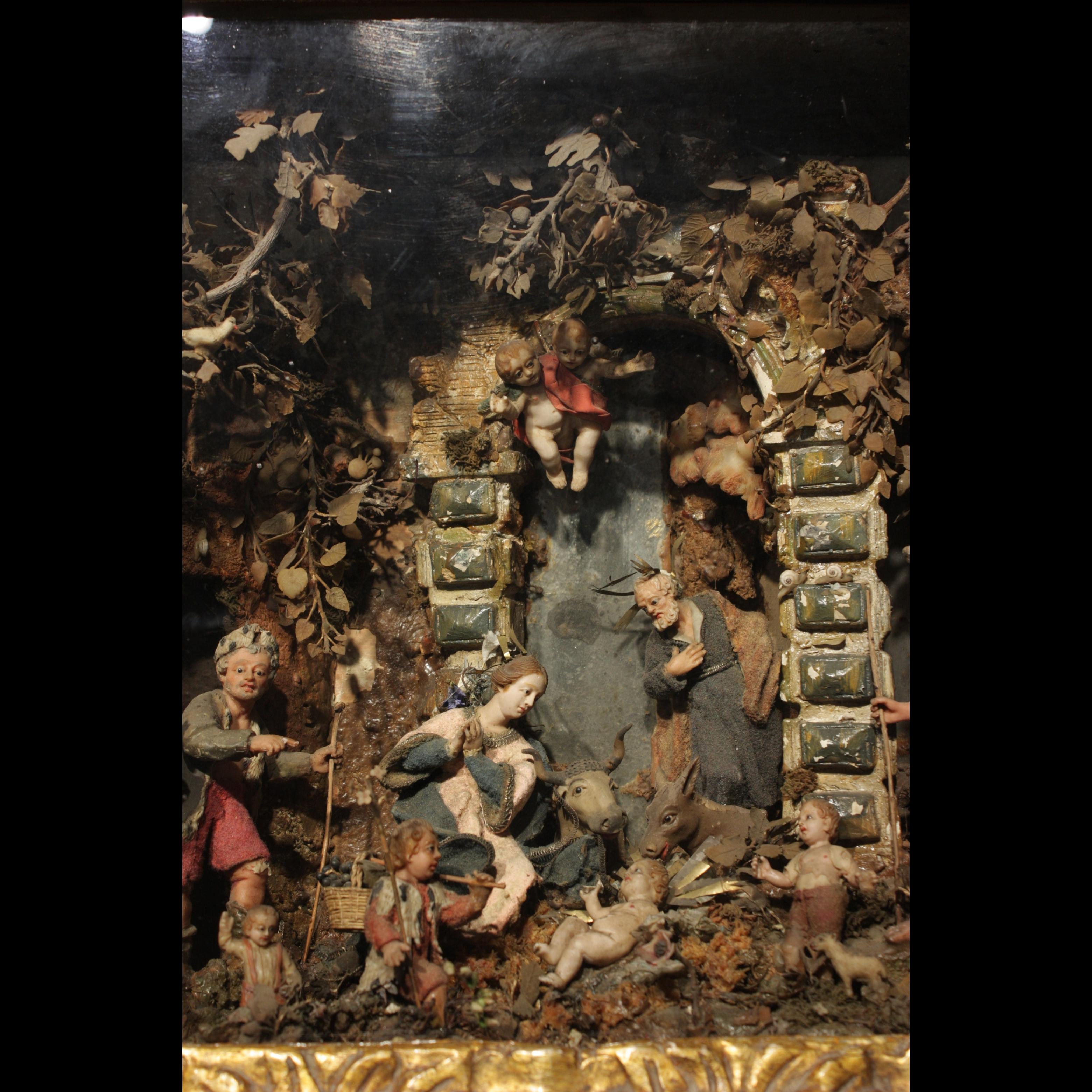 Exceptional 16th-century Neapolitan nativity scene, framed by a gilded frame with elegant marbled details in shades of green. The exquisitely decorated frame lends depth and prestige to the work, highlighting its sacred character and excellent