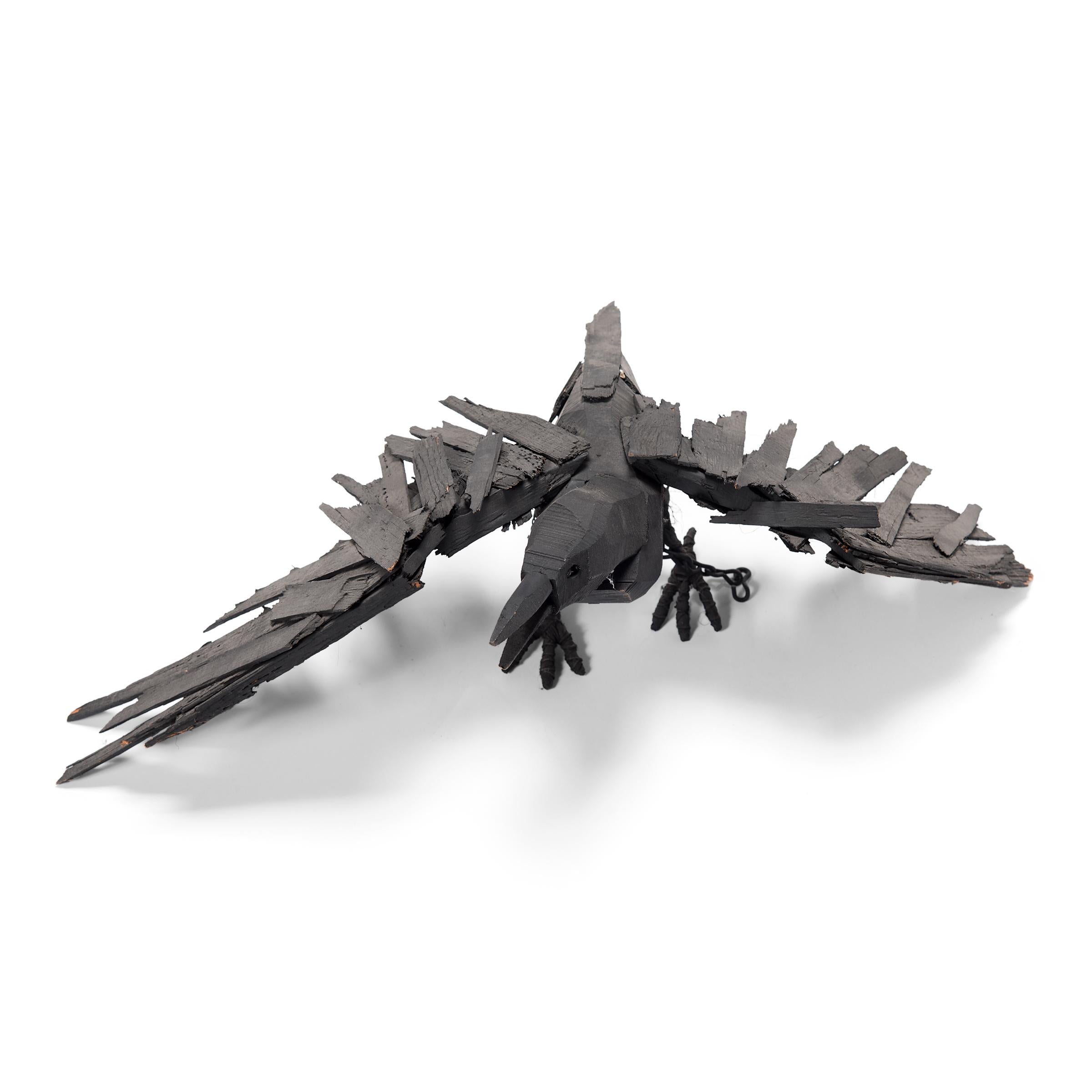 Richly textured with whimsical appeal, this late 20th century wooden crow is a delightful example of naive American sculpture. Poised mid-caw, the crow's wings are outstretched, ready to burst into flight. As though life materialized from a pile of