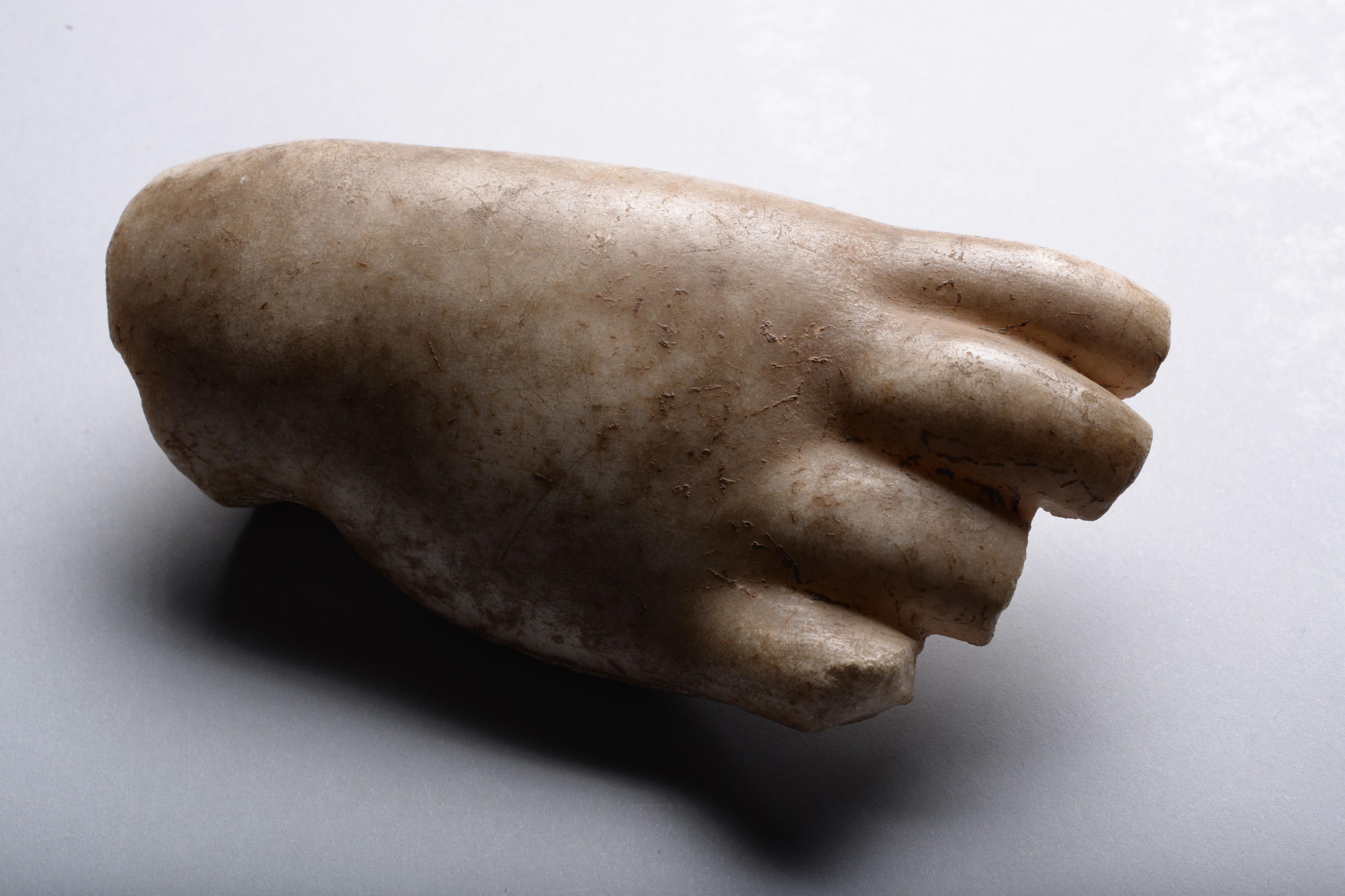 A Roman marble fragment of a hand, shown with an open palm and subtly curved fingers. The rounded and fleshy skin suggests this hand once belonged to a statue representing a child or the god of love Eros.


Provenance:

Private collection, France.