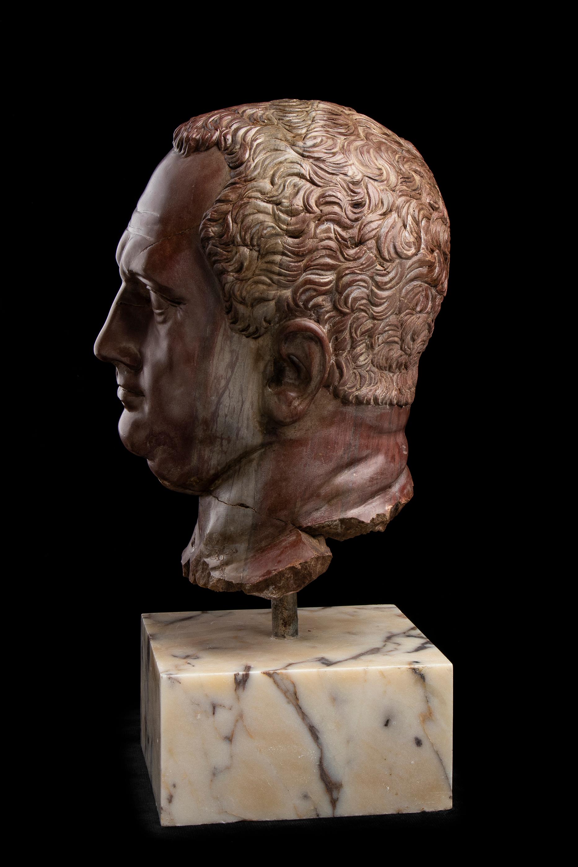 An important artistic sculptural portrait created by a master Italian sculptor, specifically from the Roman sphere, in the 19th century, depicting the Roman Emperor Vitellius.
The Rosso Antico marble head is mounted on a square base of white and