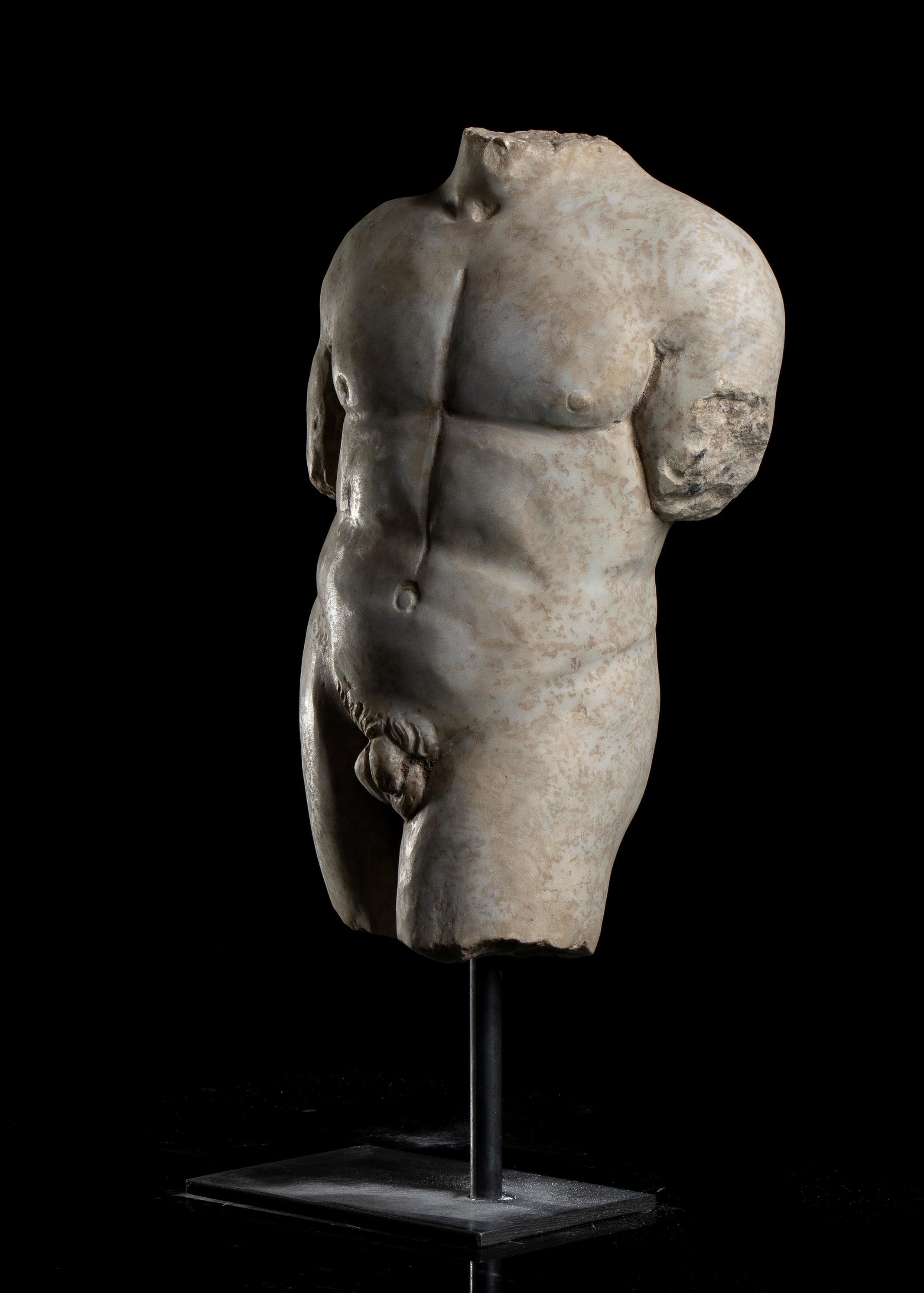Sculpture torse d'athlète en marbre grec classique romain, style grand tour, Italie centrale, début du 20e siècle.
Le site  corps nu de l'athlète debout sur sa jambe droite, la gauche avancée en position de contrapposto, la sculpture repose sur une