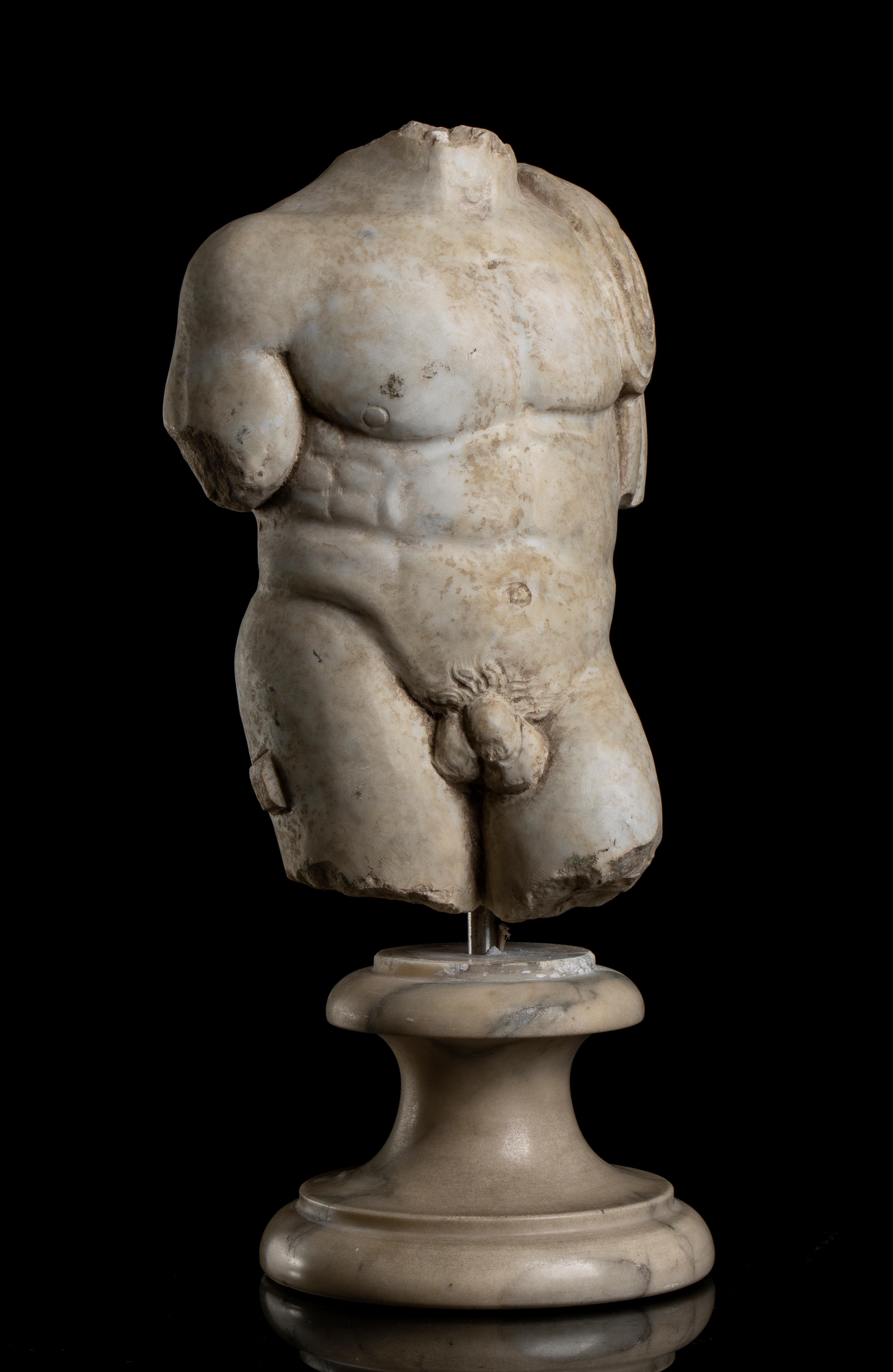 a white marble statuary aged torso sculpture of Heracles, standing on a three order circular white veined marble with a stainless steel pin.
The sculpture anatomically and detailed carved present a body of a young Hercules in contrapposto position