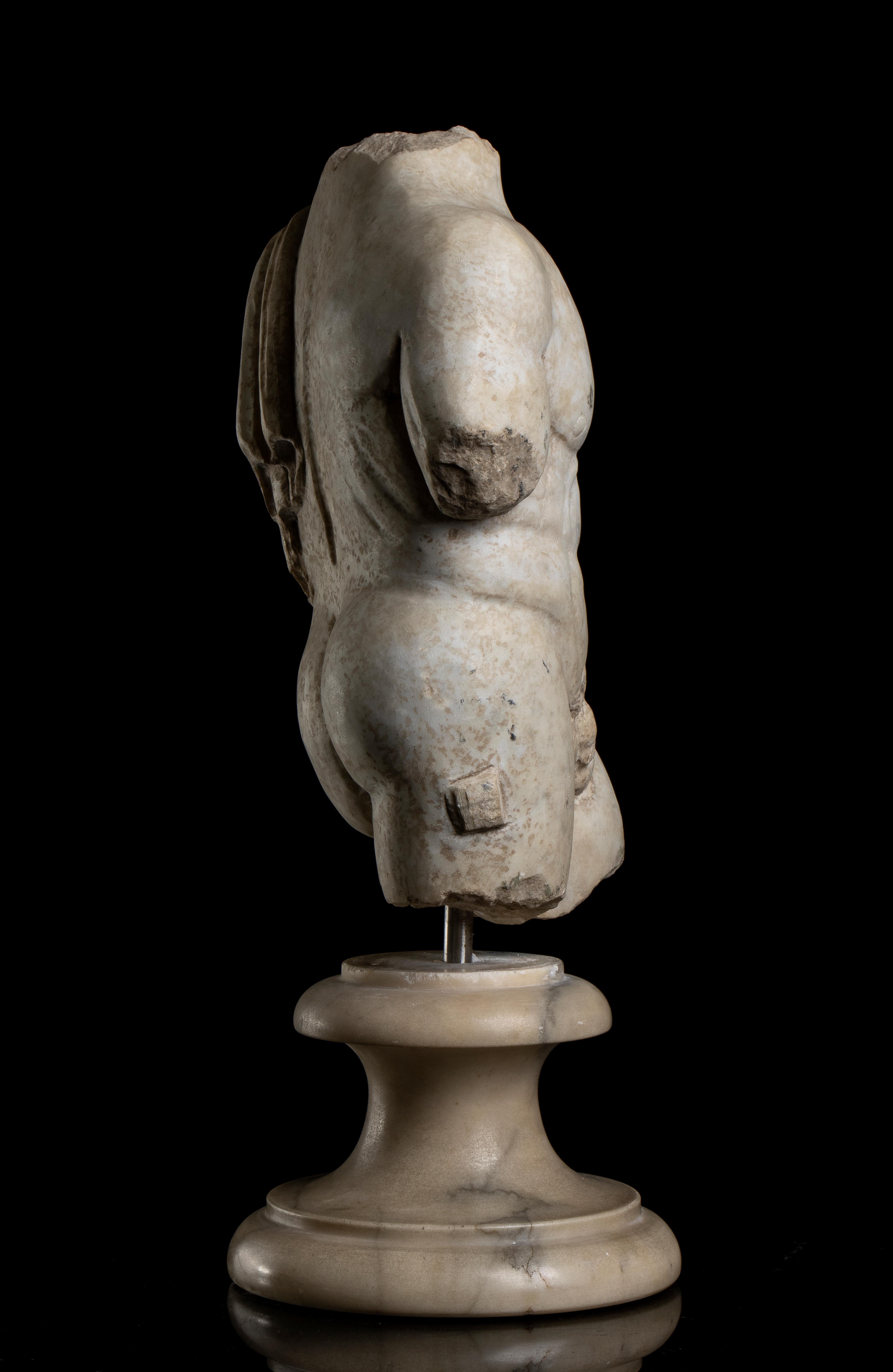 Torso des Herakles aus weißem Marmor, stehend auf einem kreisförmigen, weiß geäderten Marmorsockel mit einer Edelstahlnadel.
Die Skulptur anatomisch und detailliert geschnitzt präsentieren einen Körper eines jungen Herkules in contrapposto Position