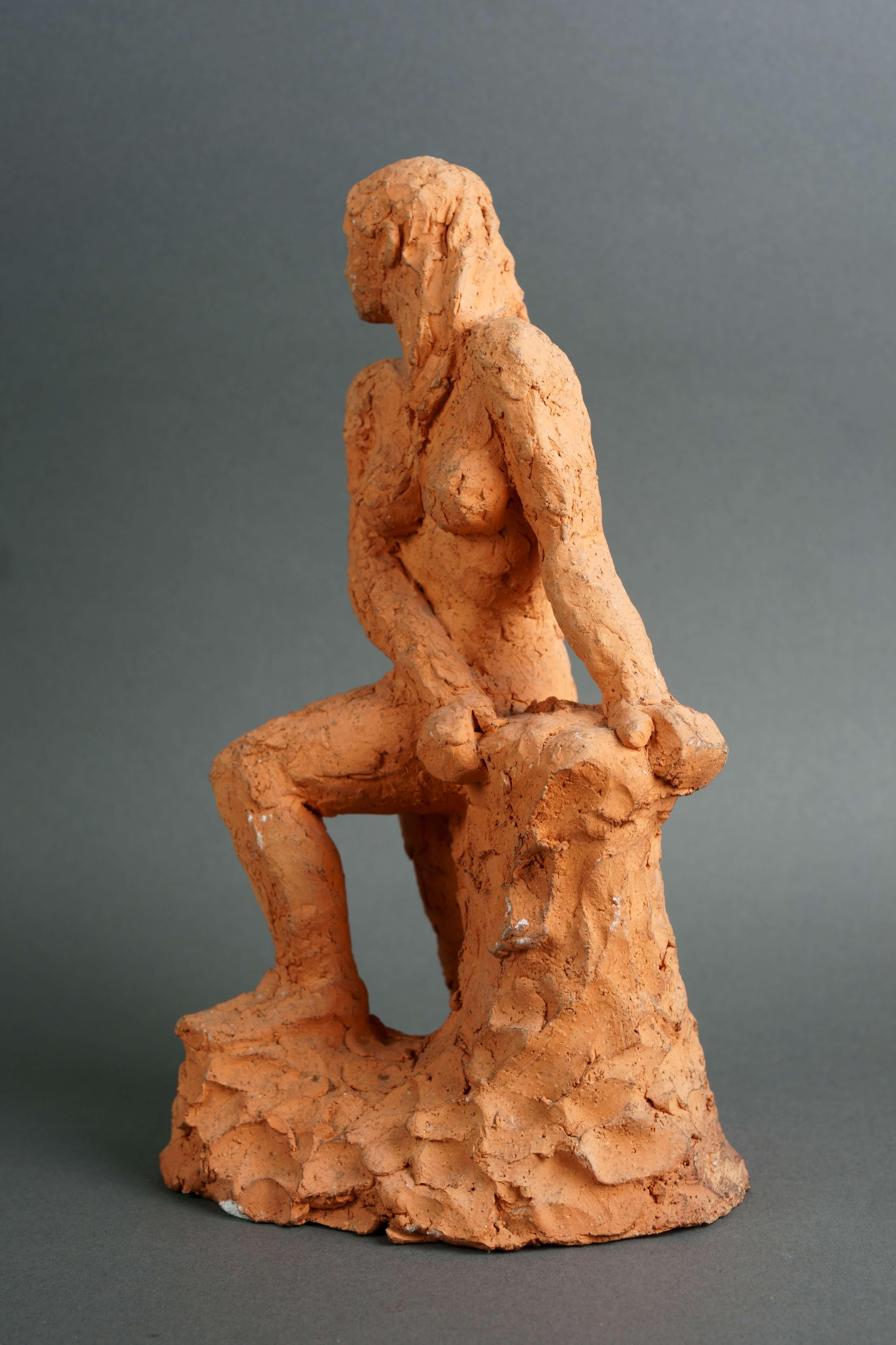 Scultura in terracotta raffigurante  un nudo di donna. Epoca XX secolo, verso il 1970.
Una giovane donna nuda che sembra emergere dalle acque, appoggiata ad uno scoglio, con i lunghi capelli che le scendono fino al petto in un'unica ciocca, come se