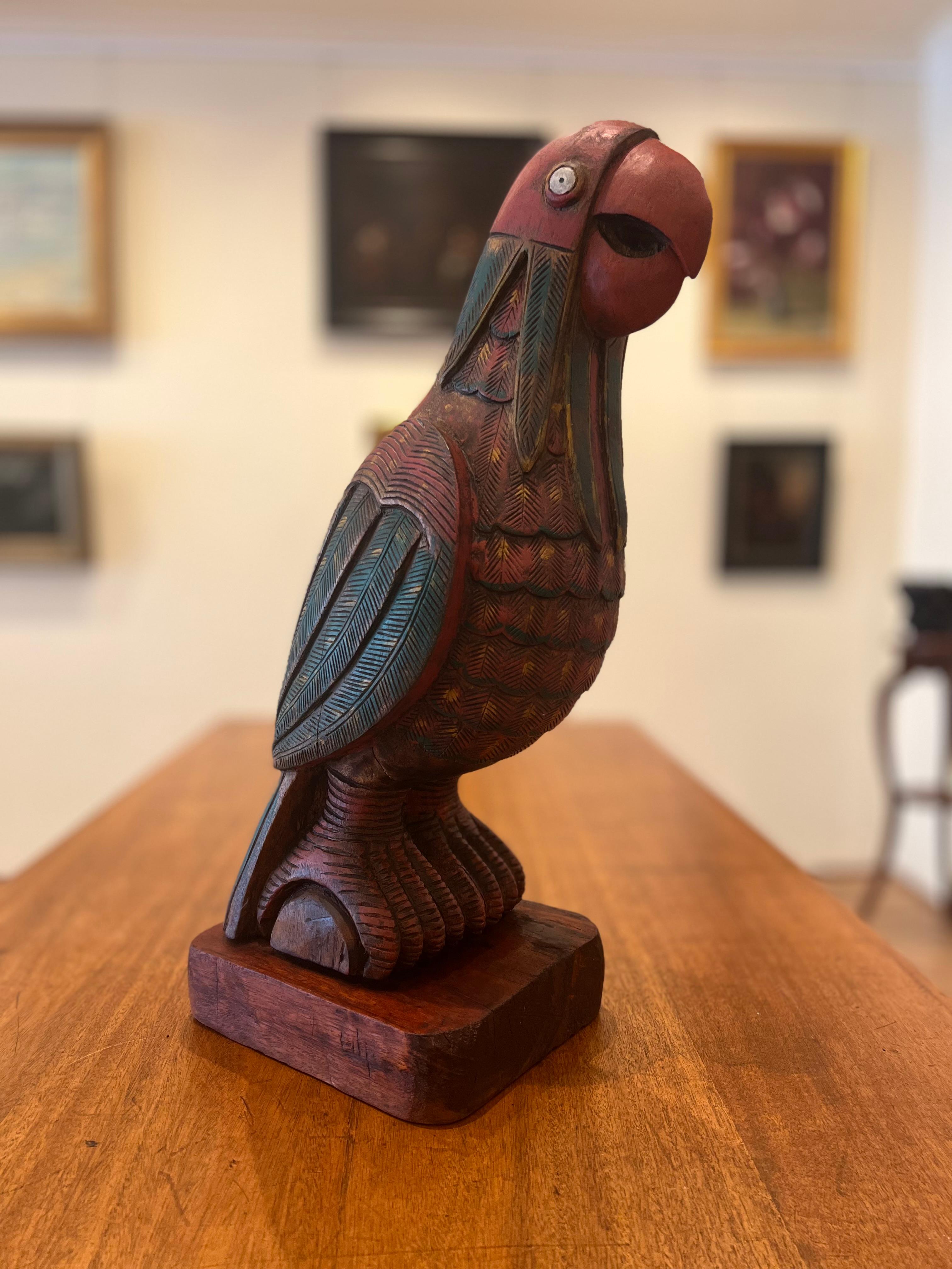 Impressionnante sculpture en cèdre polychrome d'un perroquet McCaw du début du 20e siècle. Originaire d'Amérique du Sud, ce perroquet a des proportions impressionnantes. Il présente une riche patine et porte bien son âge. C'est certainement un objet