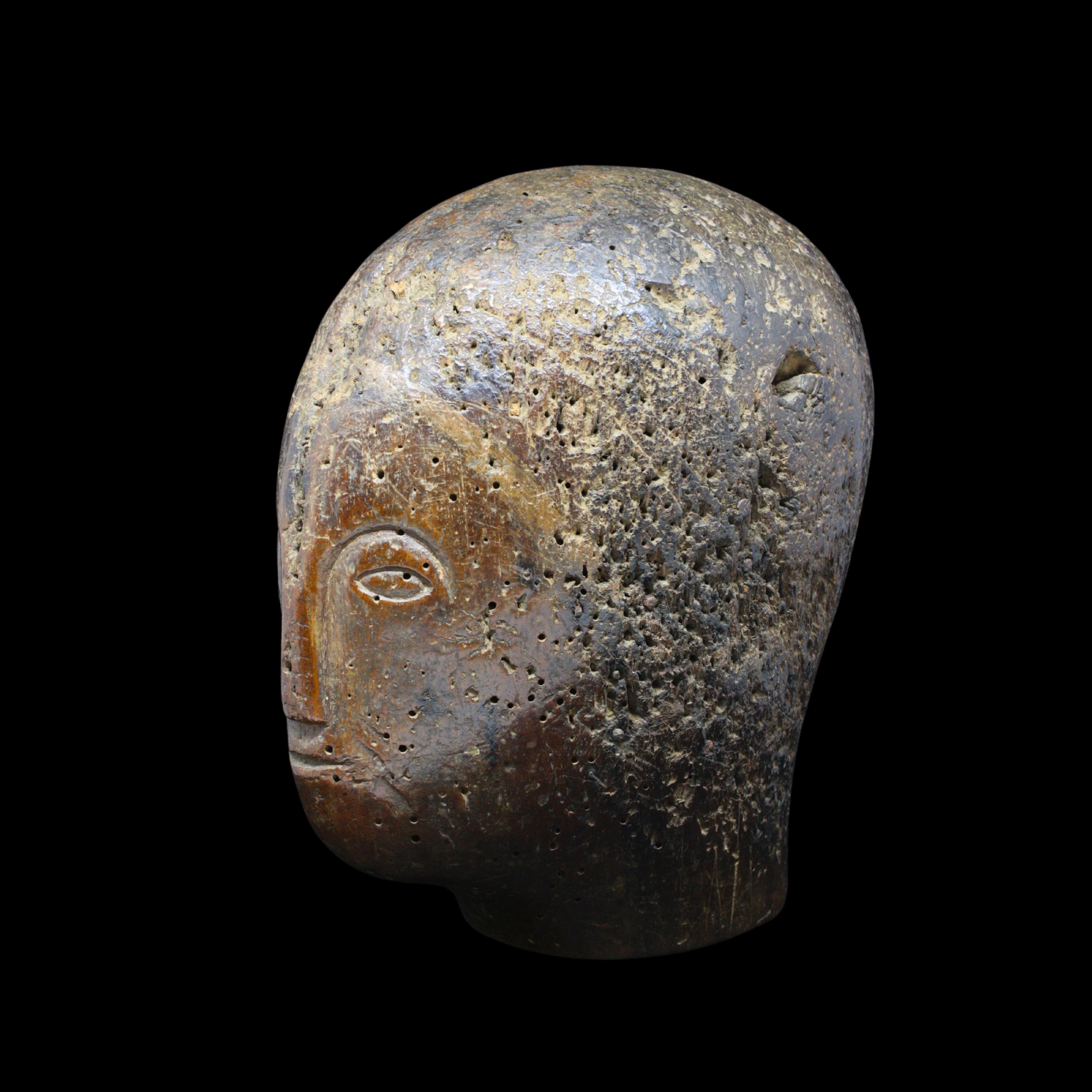 Rarísima cabeza con casco de madera, fechable entre los siglos XIII y XIV, extraordinario testimonio de la cultura material medieval. Este objeto, tallado con líneas esenciales y primitivas, servía para sujetar cascos de desfile o combate,