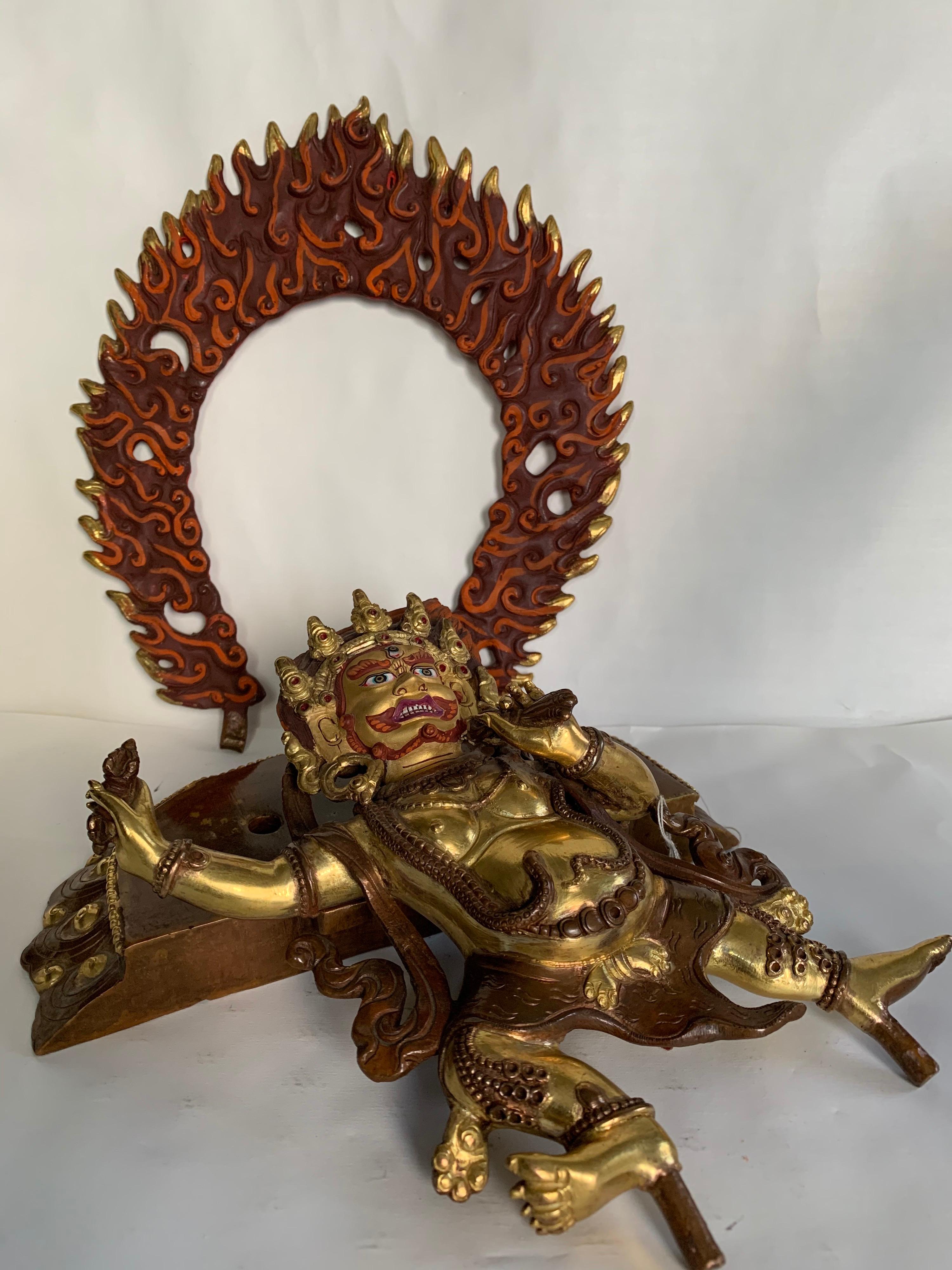 Handcrafted Vajrapani statue is made by lost wax process which is one of the ancient method of metal craft. It has a halo of fire flames behind the figure. The statue has a overlay of 24 carat gold over copper. Vajrapani is a wrathful deity of
