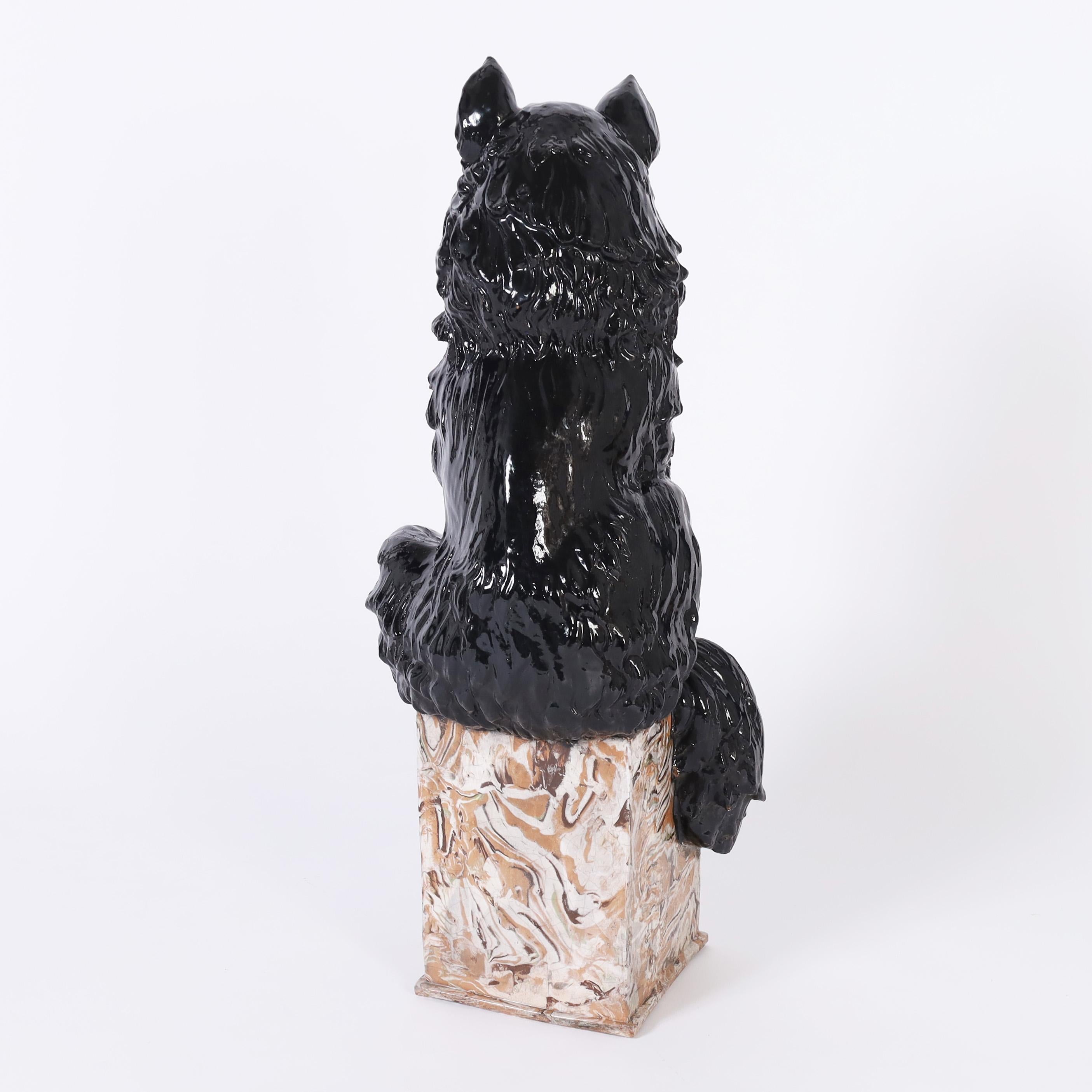 Charmante, skurrile, schwarze Katzenskulptur aus der Mitte des Jahrhunderts aus Terrakotta, handbemalt und glasiert, auf einem Sockel aus Kunstmarmor. Signiert Italien auf der Unterseite. 