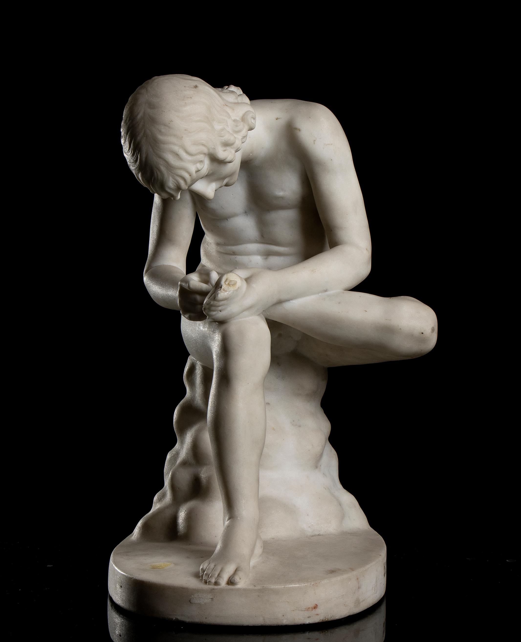 A sculpture of Boy with Thor grand tour style carved in Italy in the 19th century in white statuary marble, a scale size from the one preserved at the Uffizi Gallery in Florence.
The statue portrays a naked boy sitting on a rock, intent on removing