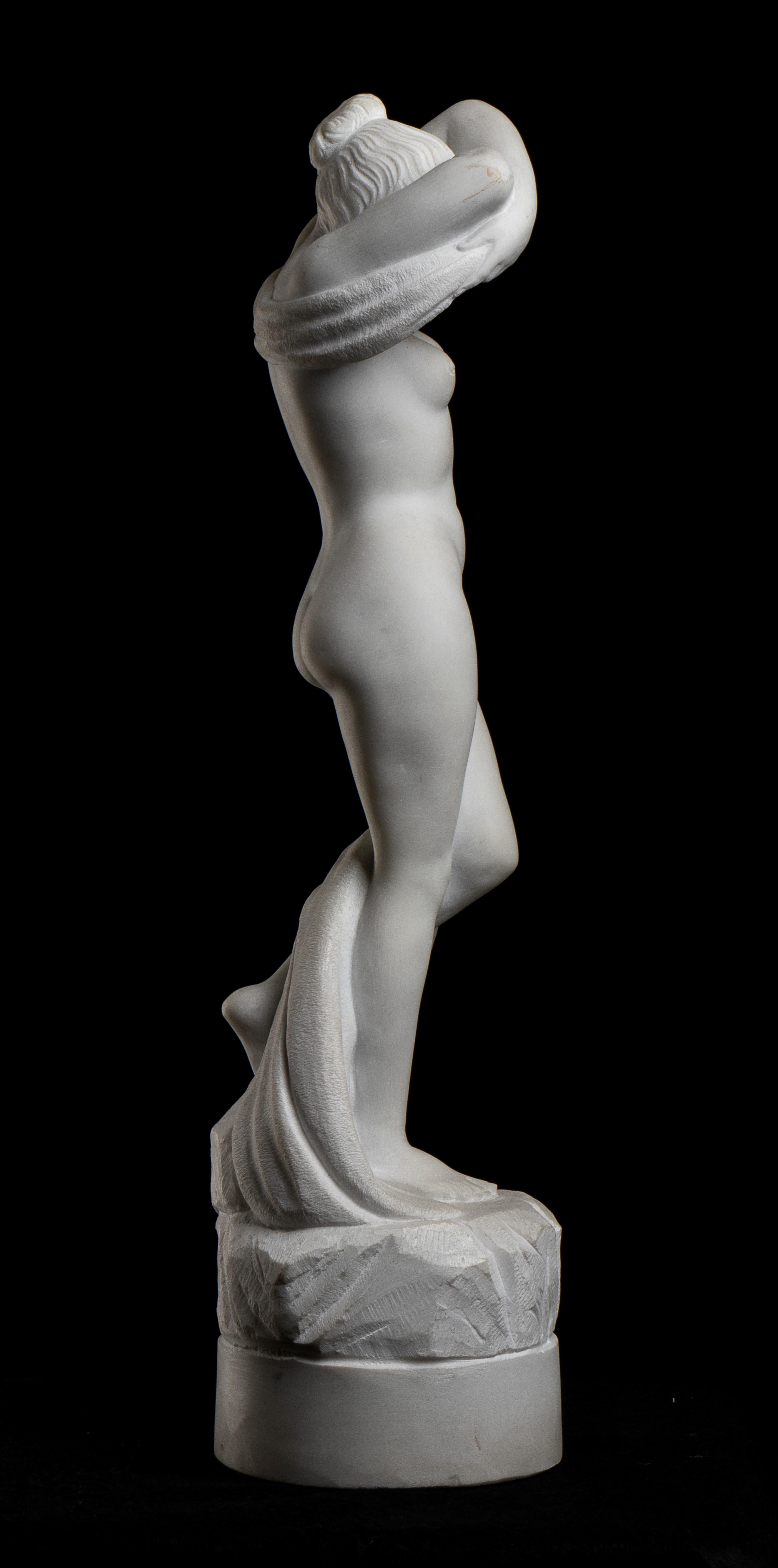 an impressive white statuary marble sculpture of a model depicting during she is undressing and the artist  is able to convey emotions that leave their mark as the sense of movement and the harmony; these are expressed with a not static artwork with