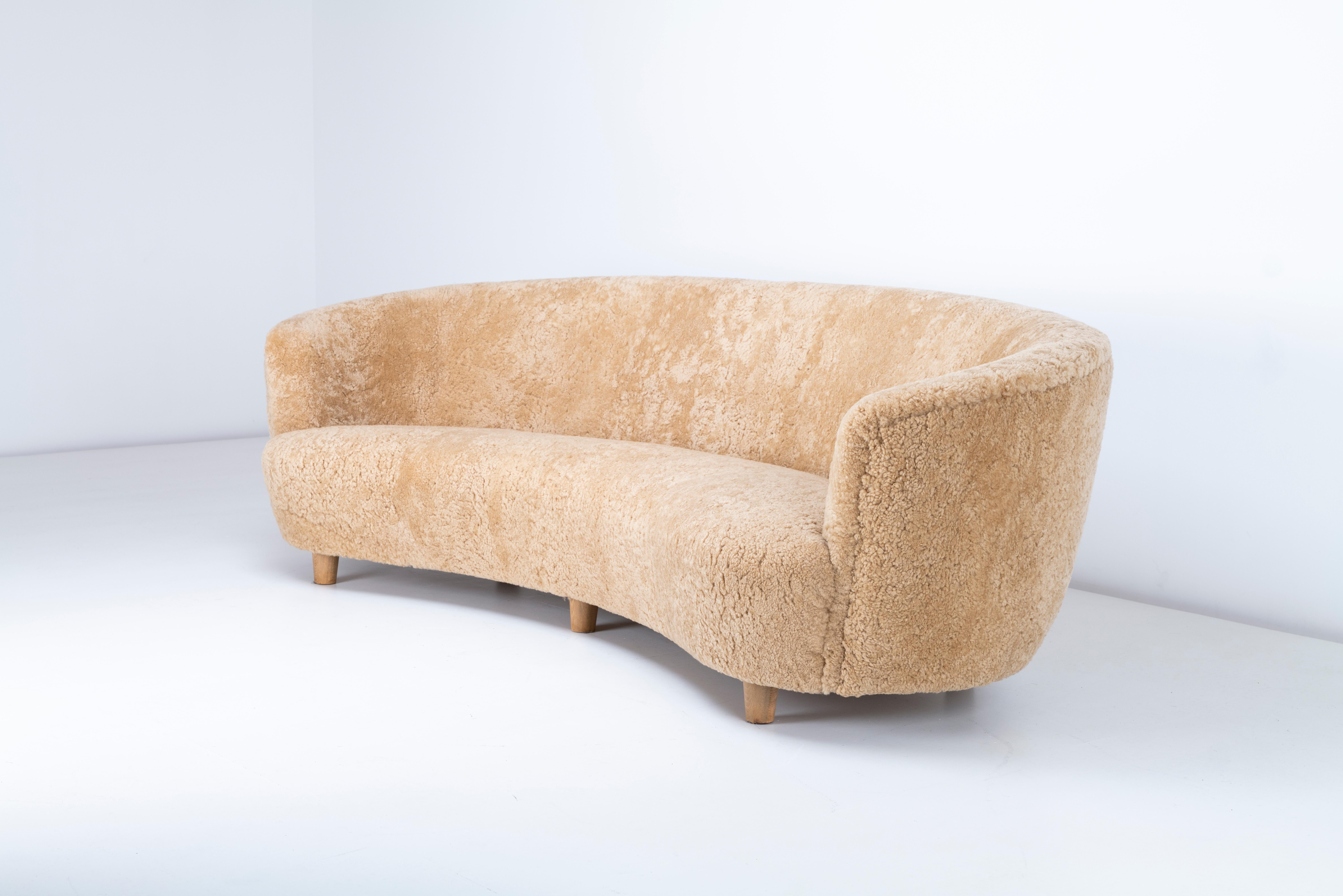 Ce superbe canapé suédois incurvé des années 1940 apporte une touche d'élégance du milieu du siècle à n'importe quel espace. Rembourré en peau de mouton couleur miel, il offre une texture douce et accueillante, à la fois luxueuse et confortable. Son