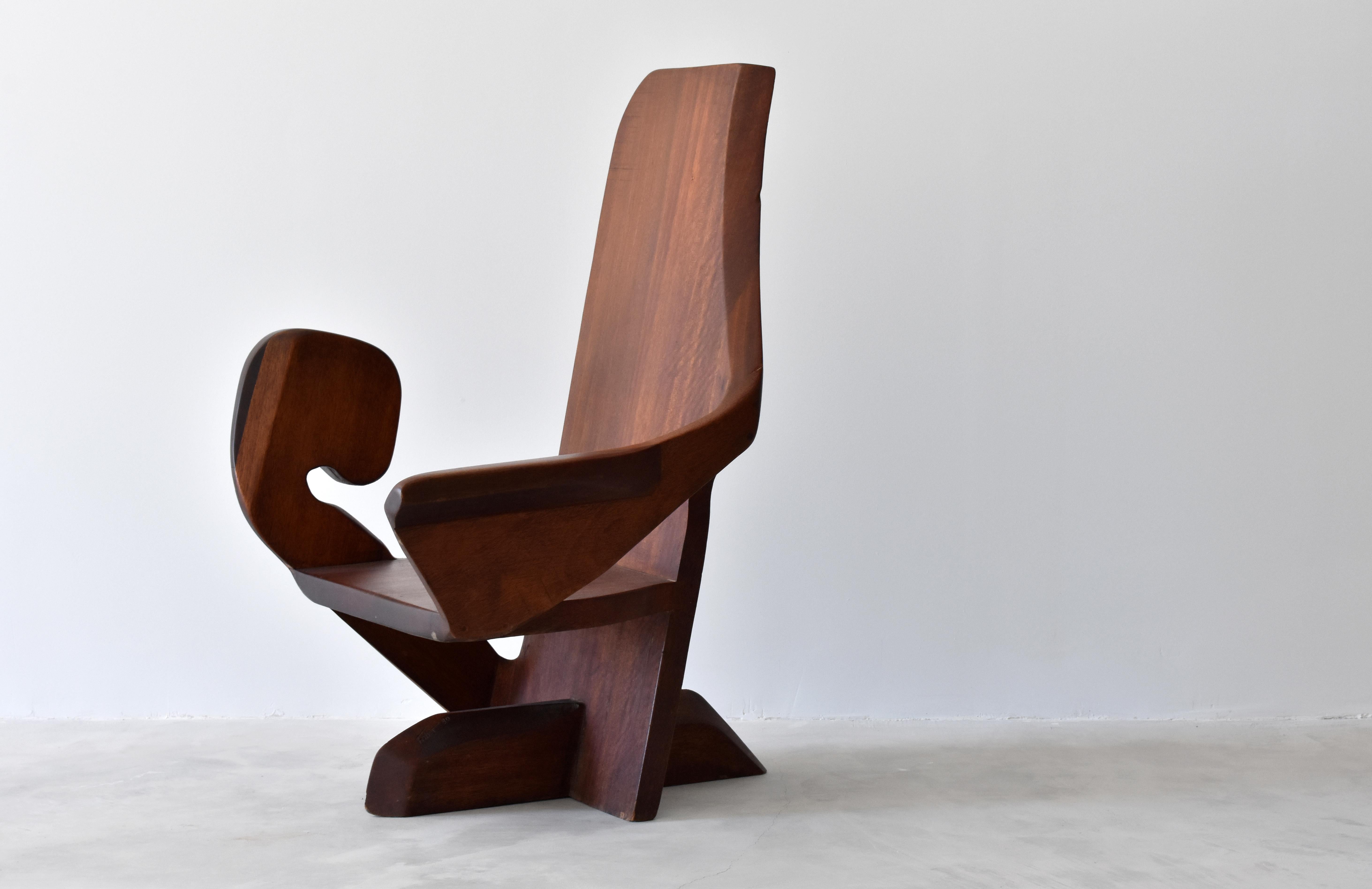 An American studio craft chair with stylized arms over T-shaped base. Hardwood slabs are meticulously sculpted into modernist form and joined together. 

