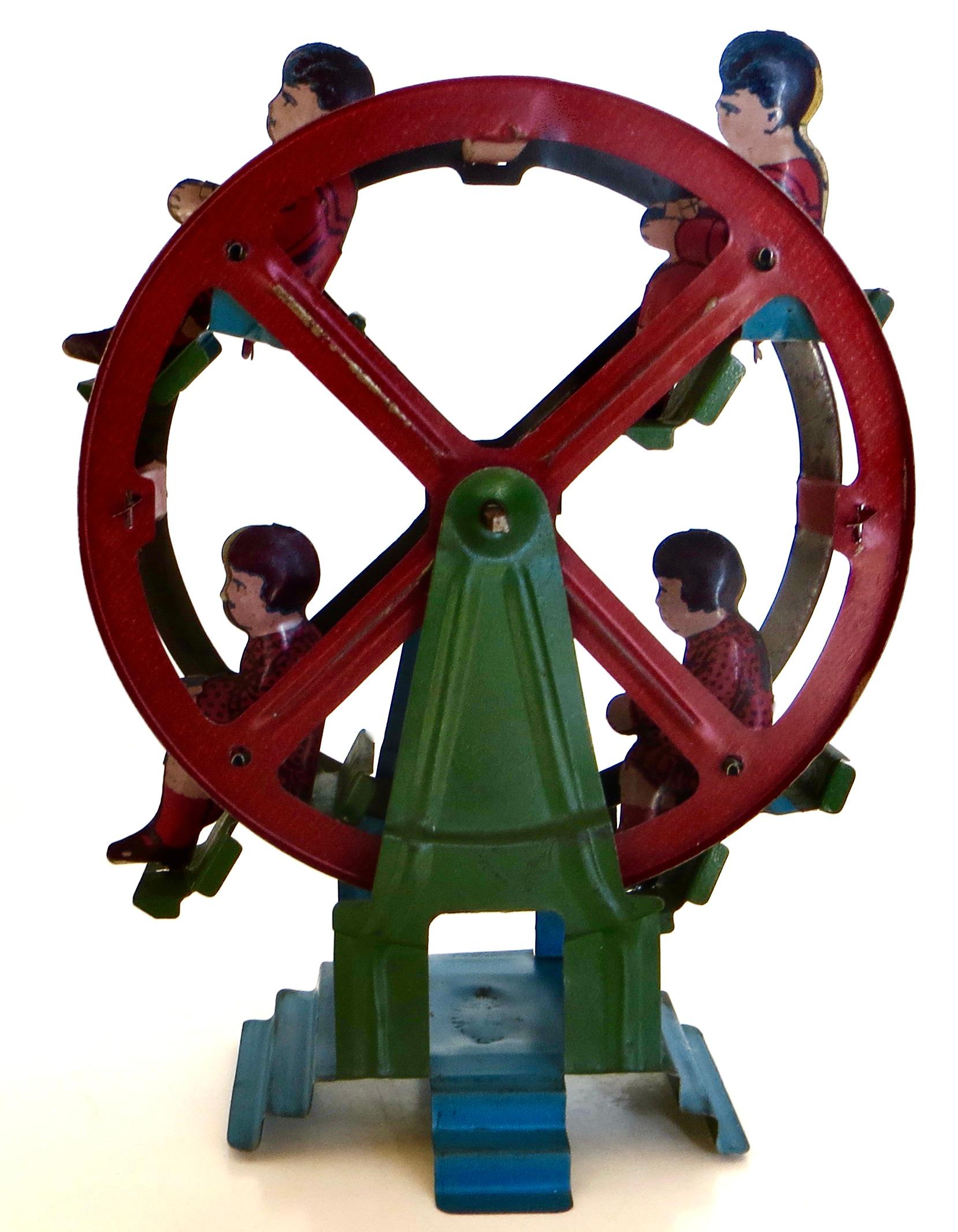 Bonita noria de 1930, pequeña y vintage, accionada por manivela, y todo original juguete infantil de hojalata. Hay cuatro niños jinetes, cada uno en un carruaje distinto. Para hacerlo funcionar: sujeta el juguete con una mano (mira el vídeo adjunto)