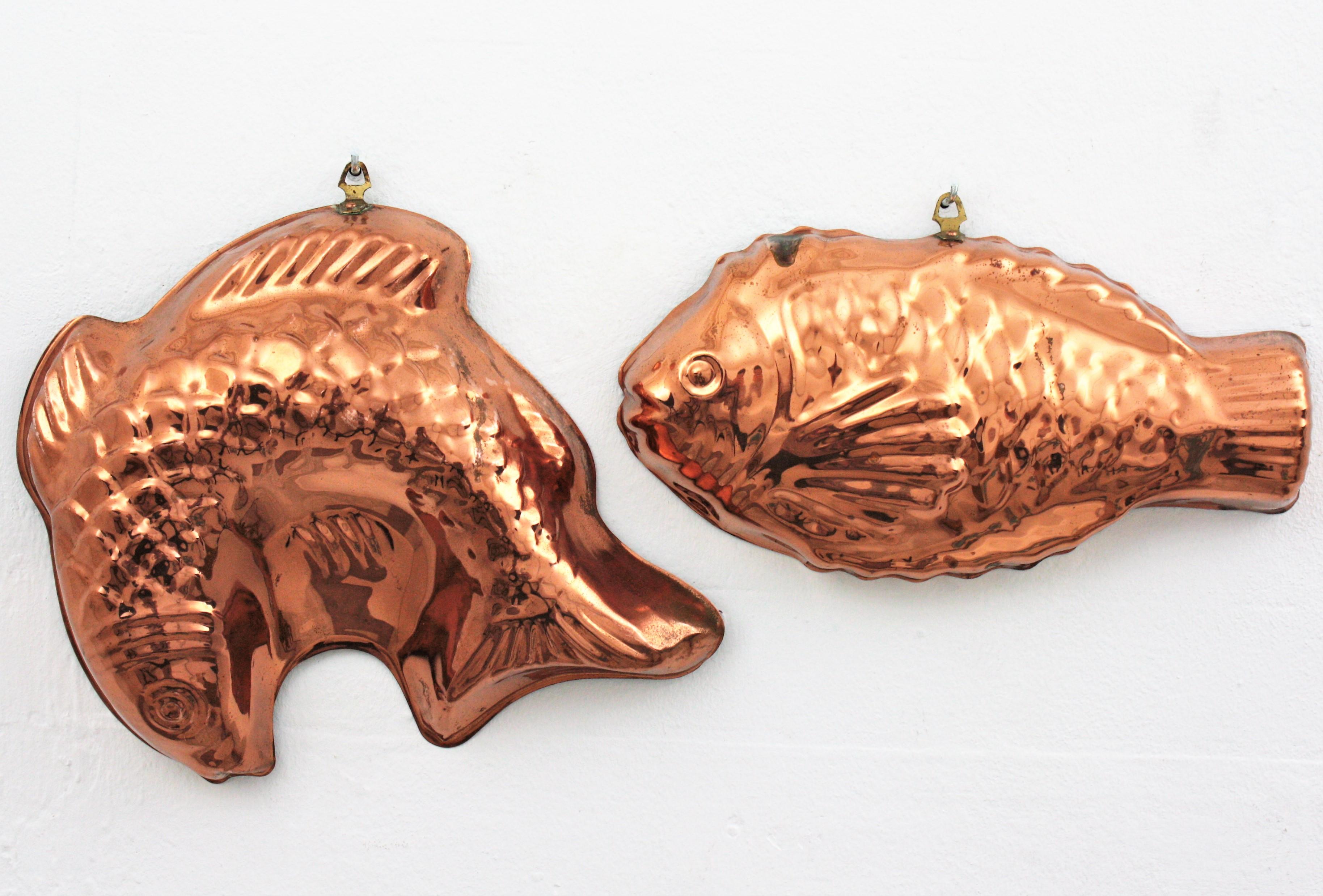 Eye-catching set of two fish shaped cake copper moulds. Portugal, 1920s-1930s
The set is comprised by a fish copper mould and a jumping fish copper mold.
Both have brass rings to hang them.
Beautiful to be used as wall decorations.
Very good