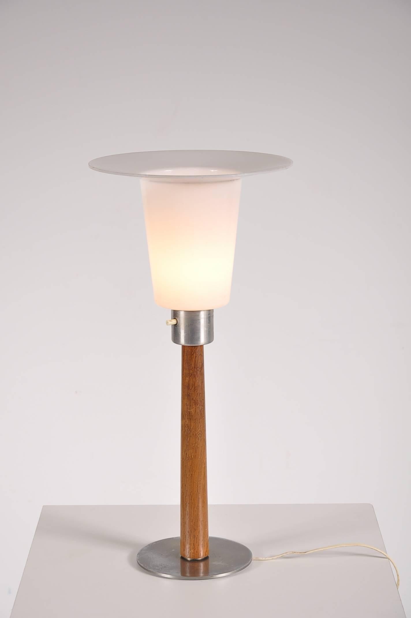 A beautiful table lamp designed by Uno & Osten Kristiansson, manufactured by Luxus in Sweden in the 1960's.

This wonderful piece has a simple, elegant design. It is made of high quality teak wood with a gray aluminium foot and plexiglass hood.