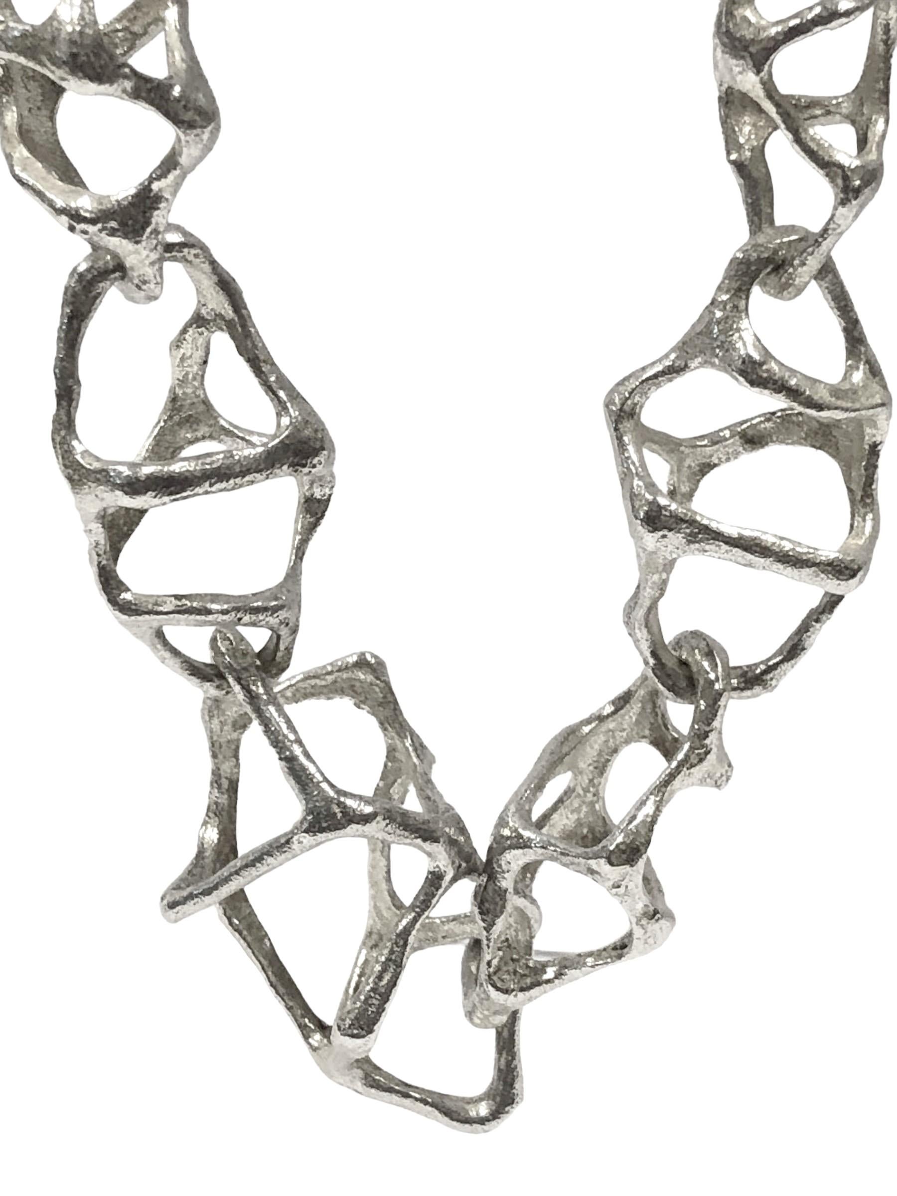 Circa 1980s Uno A Arre .835 Silver Moderninst / Brutalist link Necklace, measuring 21 1/2 inches in length with open textured links tapering in size from 3/4 down to 1/4 inch wide, weighing 86 Grams, a well made impressive piece of wearable art.
