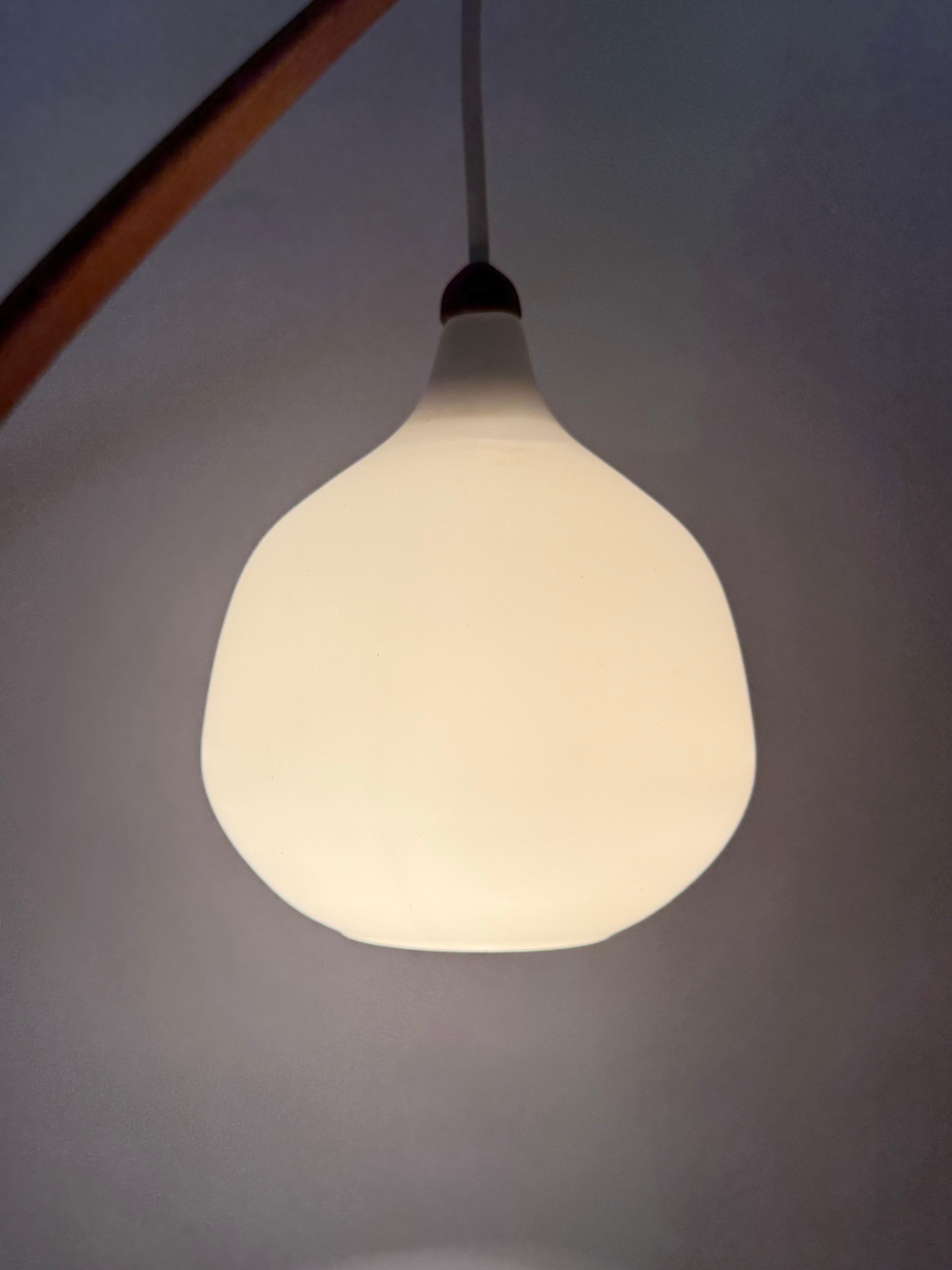 This simple, high-quality wall lamp is something special with its timeless Scandinavian design. This exclusive lamp comes from the large bungalow of a successful architect couple. The beautifully shaped teak wood is very finely crafted and crafted
