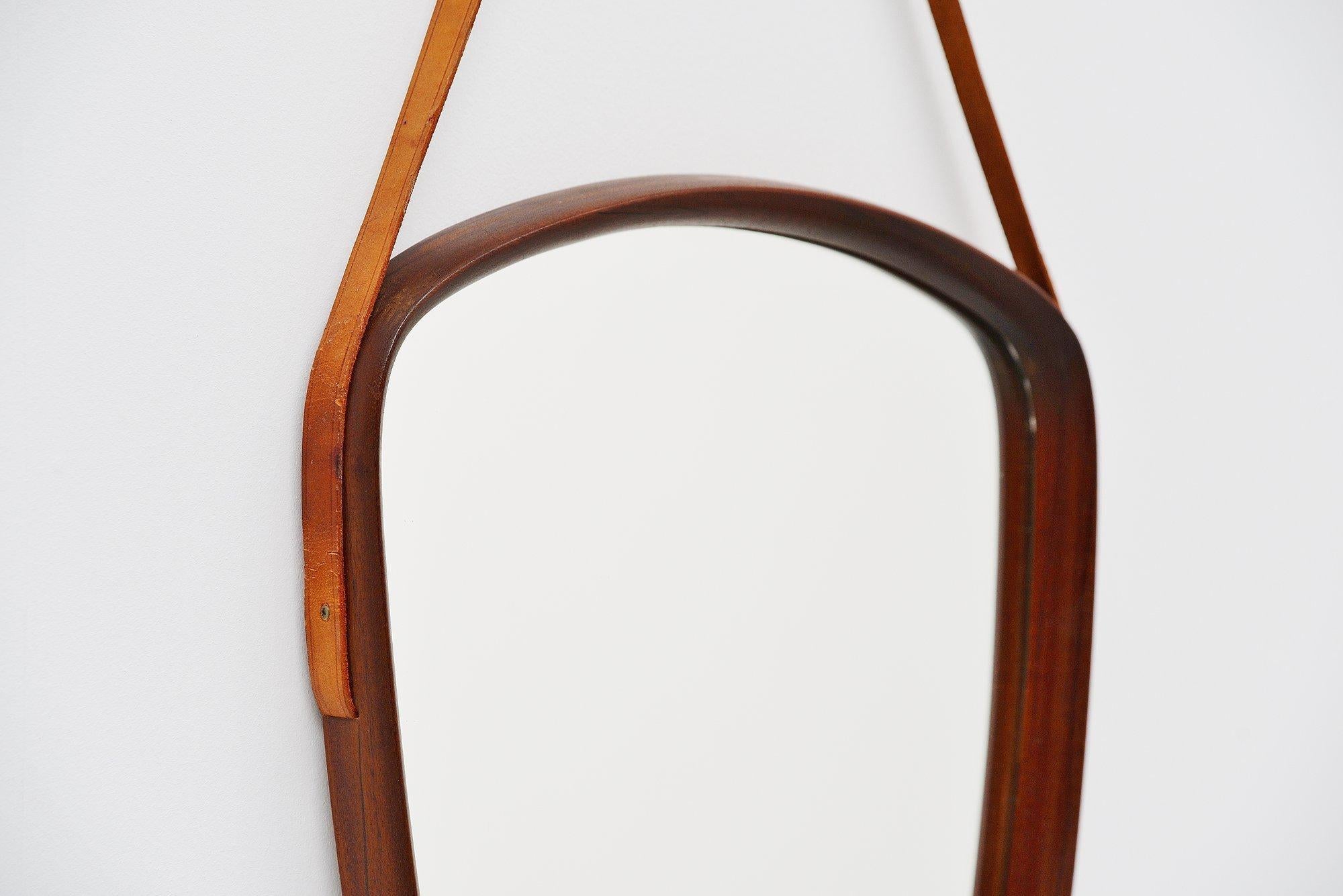 Very nice shaped wall mirror designed by Uno and Osten Kristiansson and manufactured by Luxus, Sweden 1960. The mirror has a rosewood rim and natural leather strap to hang it. Very nice and unusual shape and in very good original condition. Easy to