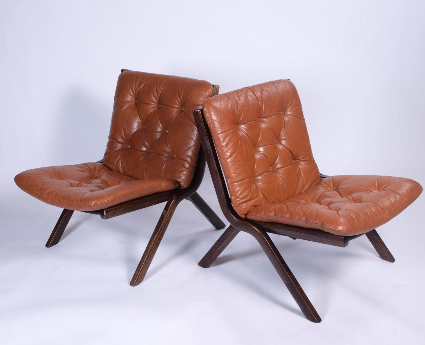 Crafted around 1970 in Norway, this vintage leather chair exudes timeless charm. Its curved, stained beechwood frame boasts a warm auburn tint, complementing the sumptuous caramel tan leather adorning the seat and back. The sinuous design, a