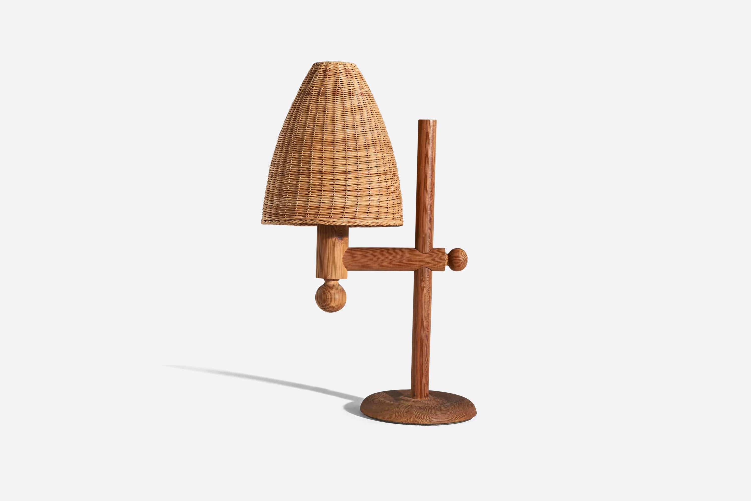 A sizeable solid pine and rattan table lamp designed by Uno Kristiansson and produced by Luxus, Sweden, 1970s. 

Variable dimensions, measured as illustrated in the first image. 

Sold with lampshade. 
Dimensions of lamp (inches) : 24.87 x 10 x