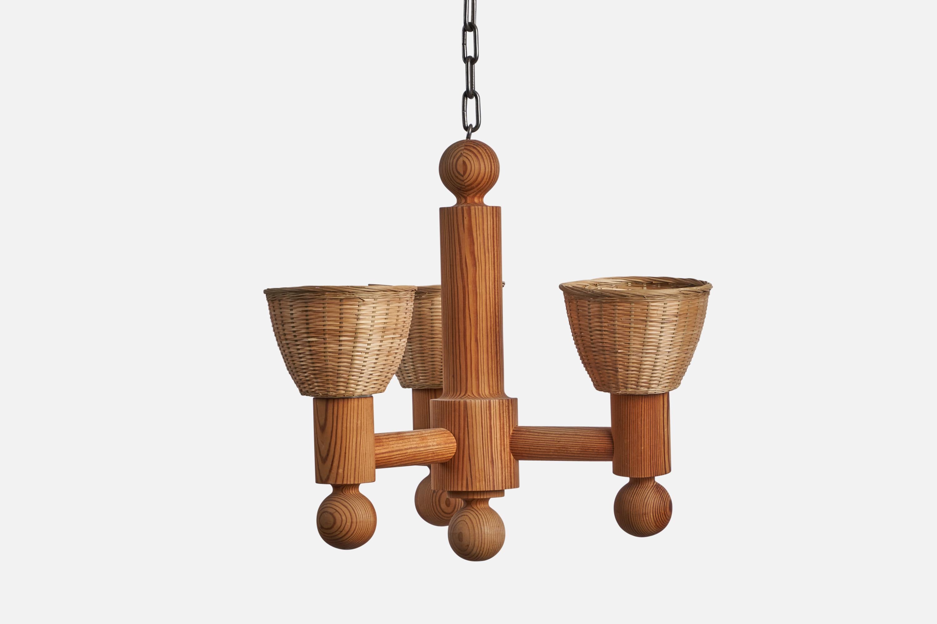 A three-armed pine and rattan chandelier designed by Uno Kristiansson and produced by Luxus Vittsjö, Sweden, 1970s

Overall Dimensions (inches): 19” H x 20.5” Diameter
Chain Drop Length (inches): 26” L
Bulb Specifications: E-26 Bulb
Number of