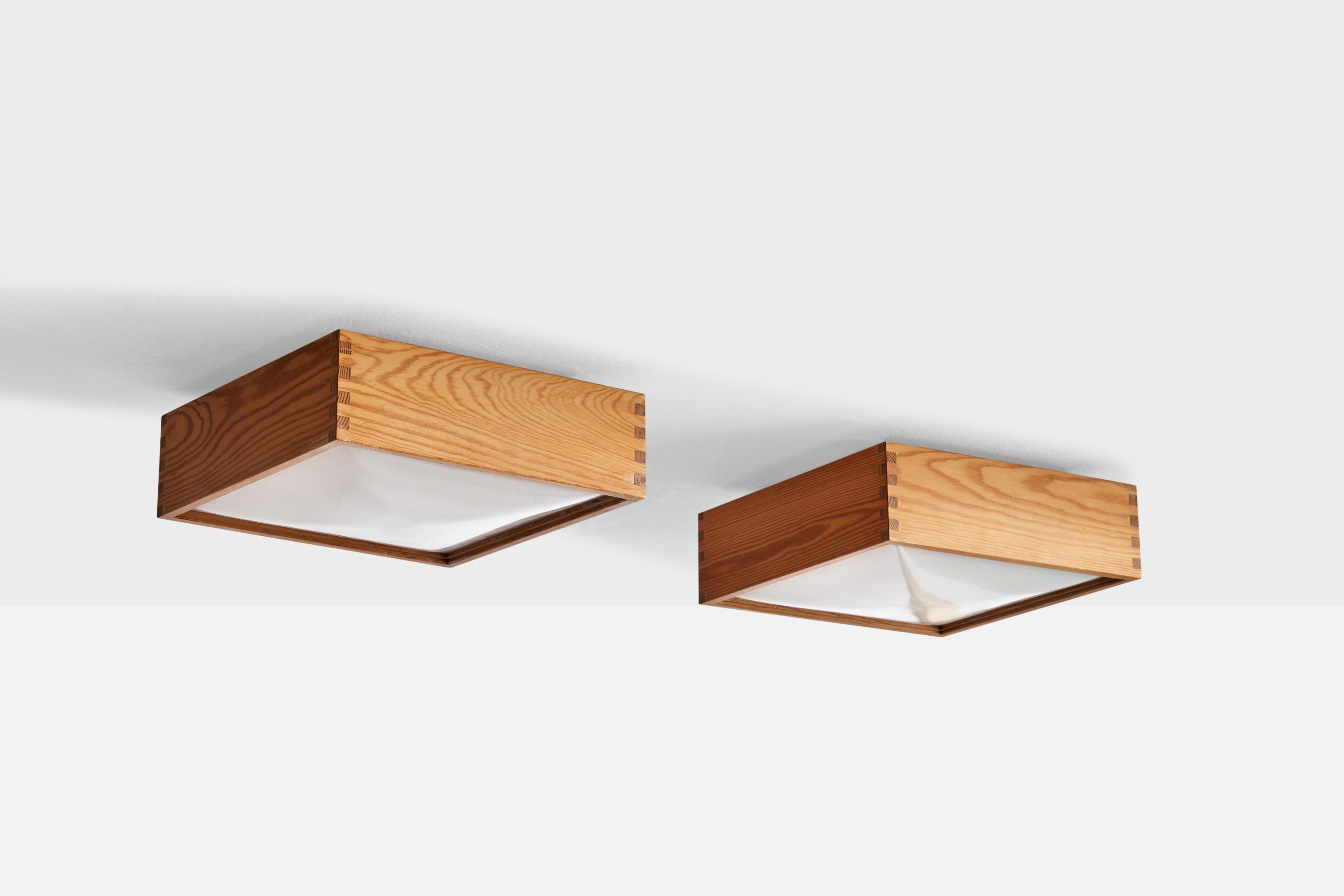 A pair of pine and acrylic flush mounts designed by Uno & Östen Kristiansson and produced by Luxus, Vittsjö, Sweden, c. 1970s.

Overall Dimensions (inches): 3.75”  H x 11.75” W x 11.75” D
Back Plate Dimensions (inches): 8” H x 8.75” W x .50”  D
Bulb