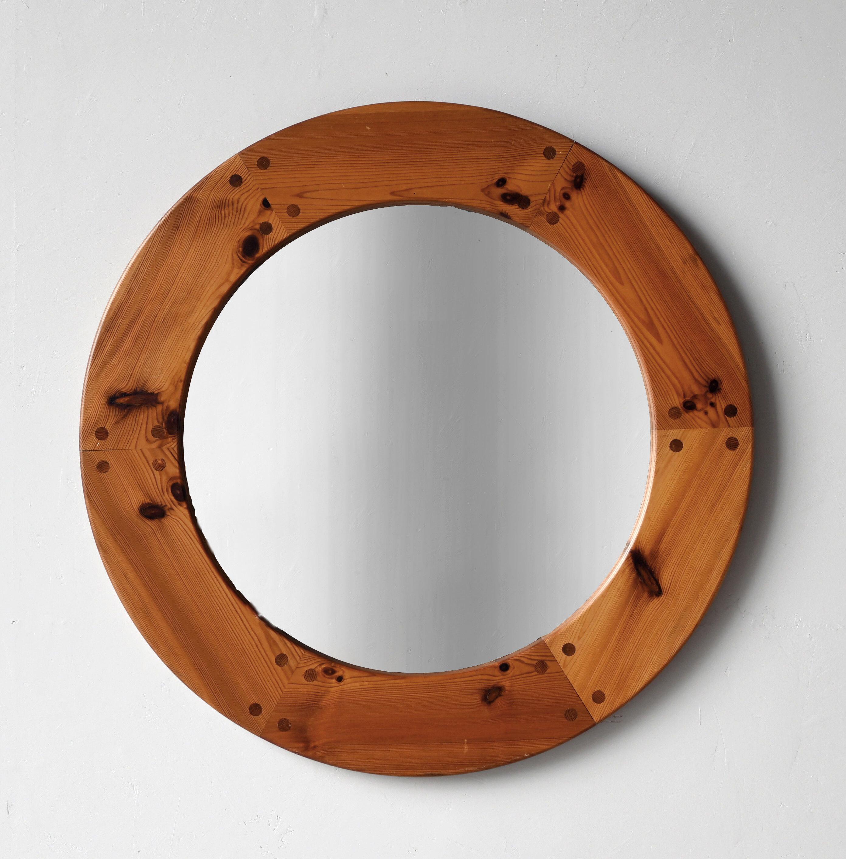 A sculptural round wall mirror. Rare very large version. Designed by Uno Kristiansson, for Luxus, Sweden, 1960s. Features revealed teak-colored joinery. 

Other designers of the period include Axel Einar Hjorth, Roland Wilhelmsson, Charlotte