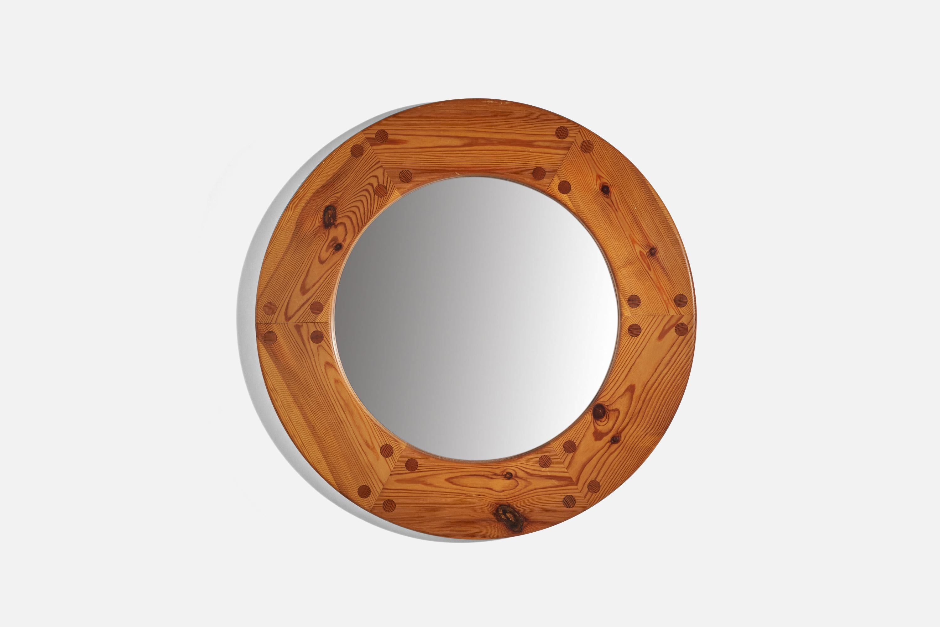 A solid pine round wall mirror designed by Uno Kristiansson and produced by Luxus, Sweden, 1960s.