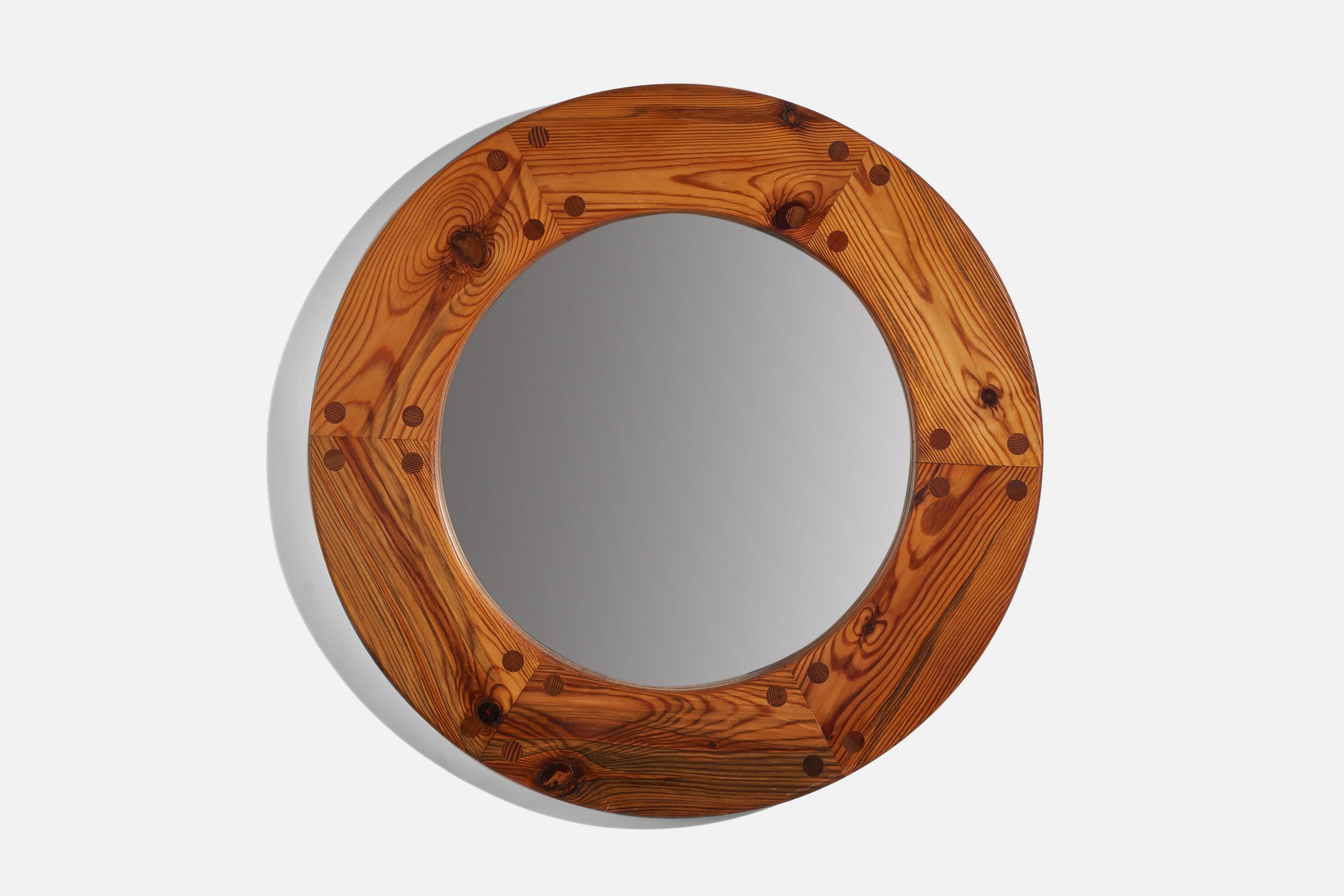 A solid pine round wall mirror designed by Uno Kristiansson and produced by Luxus, Sweden, 1960s. 