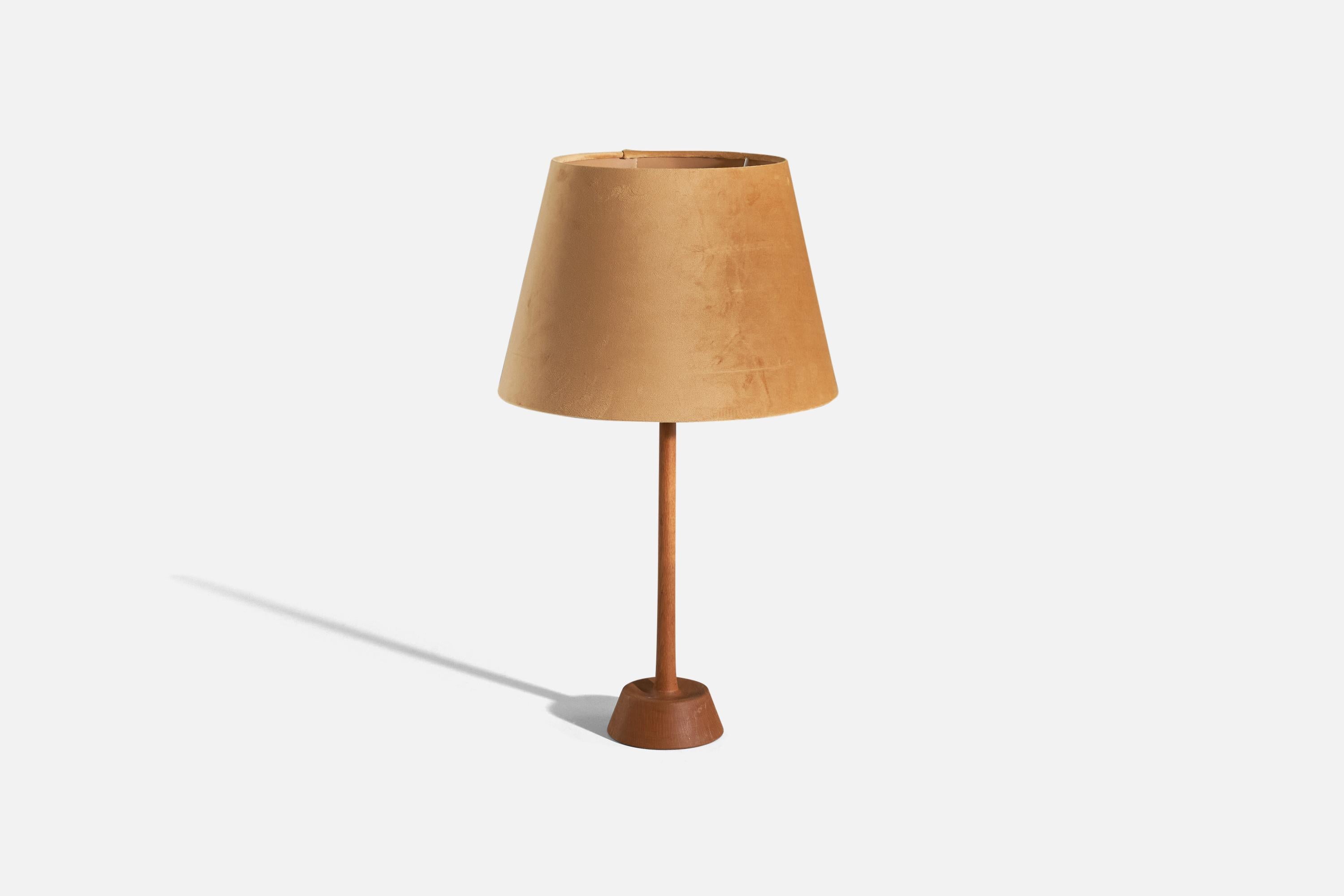 An oak and fabric table lamp designed by and produced by Uno Kristiansson, Sweden, 1970s. 

Sold with lampshade. 
Dimensions of Lamp (inches) : 17.75 x 4.93 x 4.93 (H x W x D)
Dimensions of Shade (inches) : 9.5 x 13.75 x 9.75 (T x B x