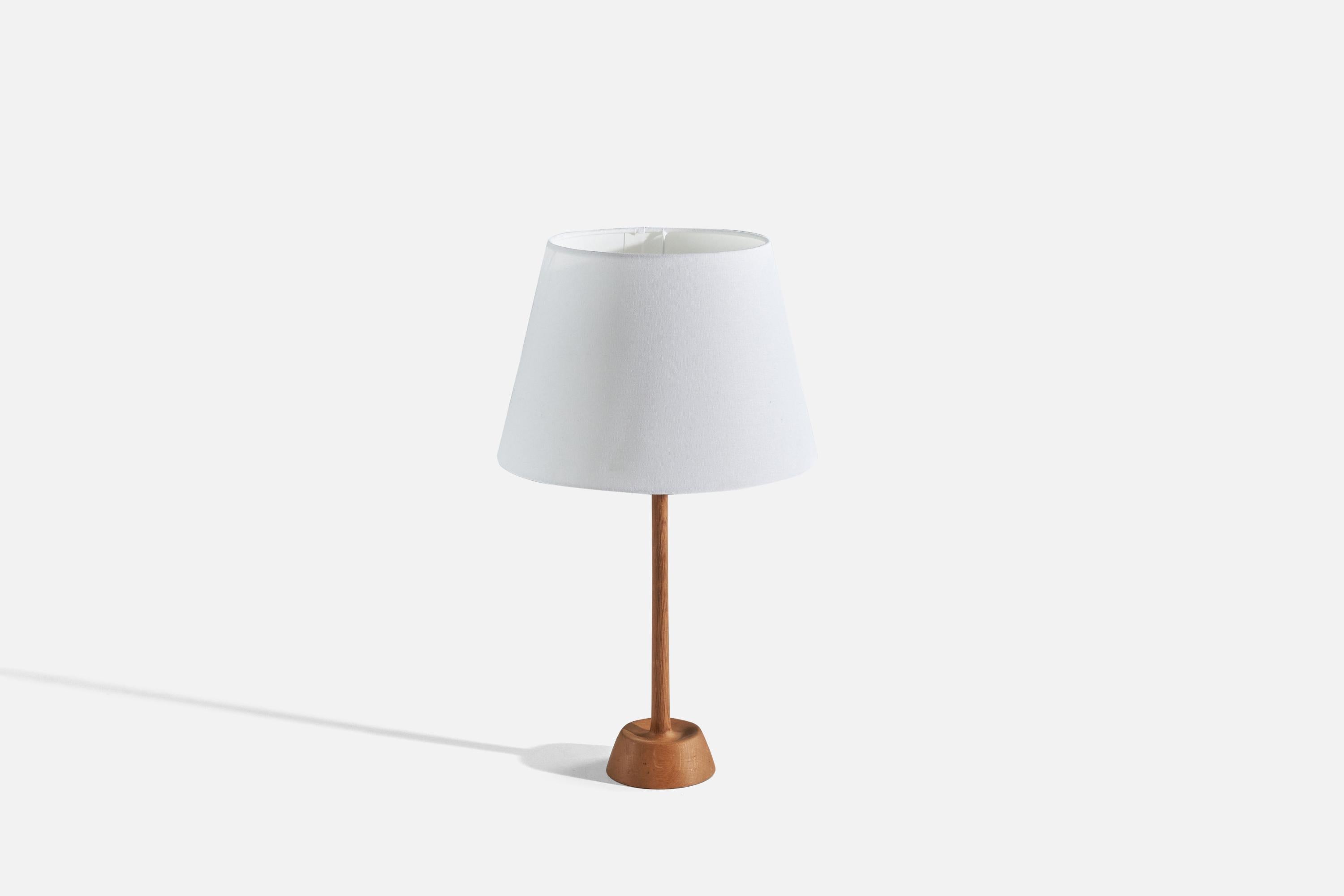 An oak and fabric table lamp designed by and produced by Uno Kristiansson, Sweden, 1970s. 

Lampshade can be included upon request.
 
Dimensions of Lamp (inches) : 18 x 4.87 x 4.87 (Height x Width x Depth)
Dimensions of Shade (inches) : 9.37 x 13.81