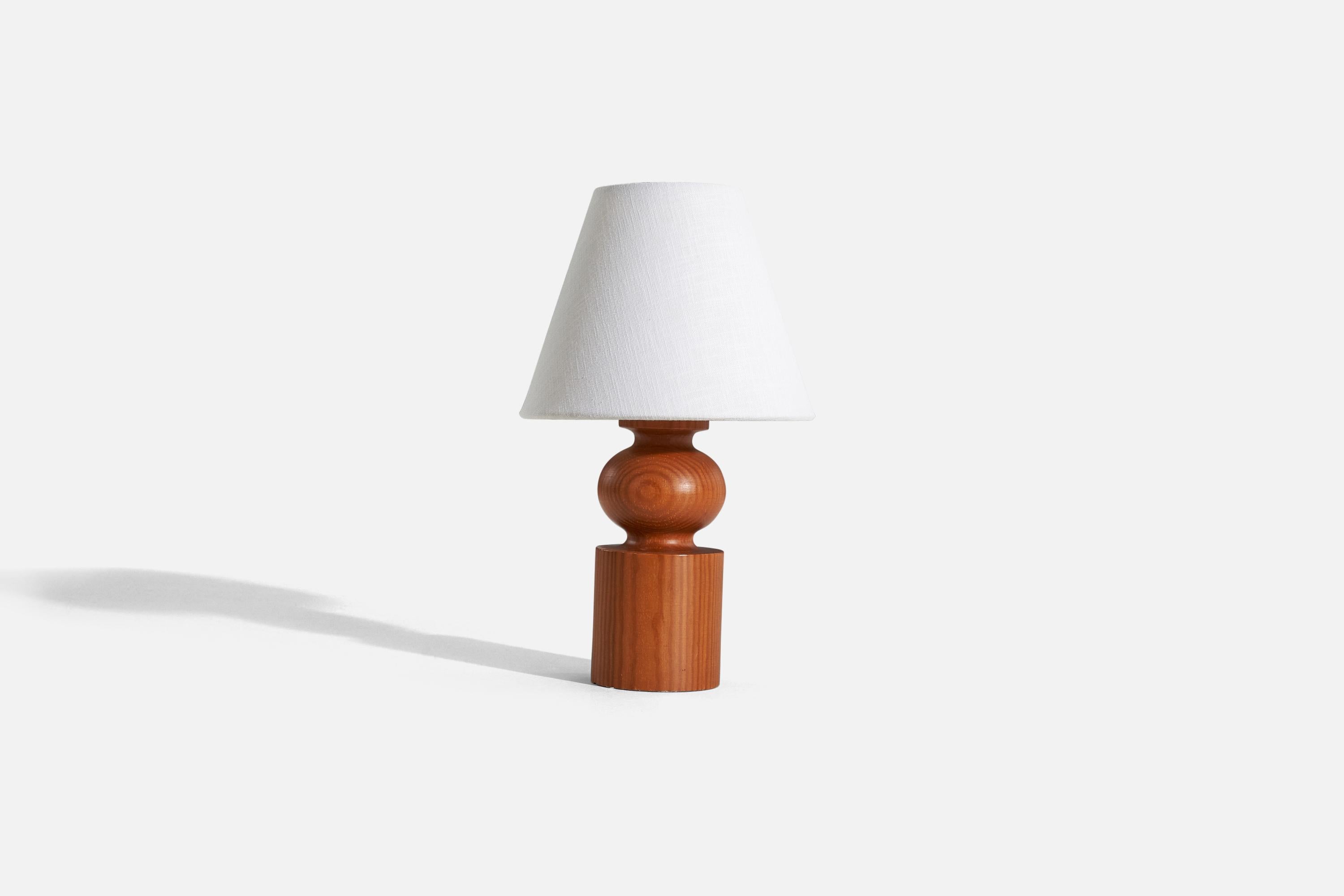 A solid pine table lamp designed by Uno Kristiansson and produced by Luxus, Sweden, 1960s.

Sold without lampshade. 
Dimensions of lamp (inches) : 9.5 x 3.5625 x 3.5625 (H x W x D)
Dimensions of shade (inches) : 4 x 8 x 6.5 (T x B x