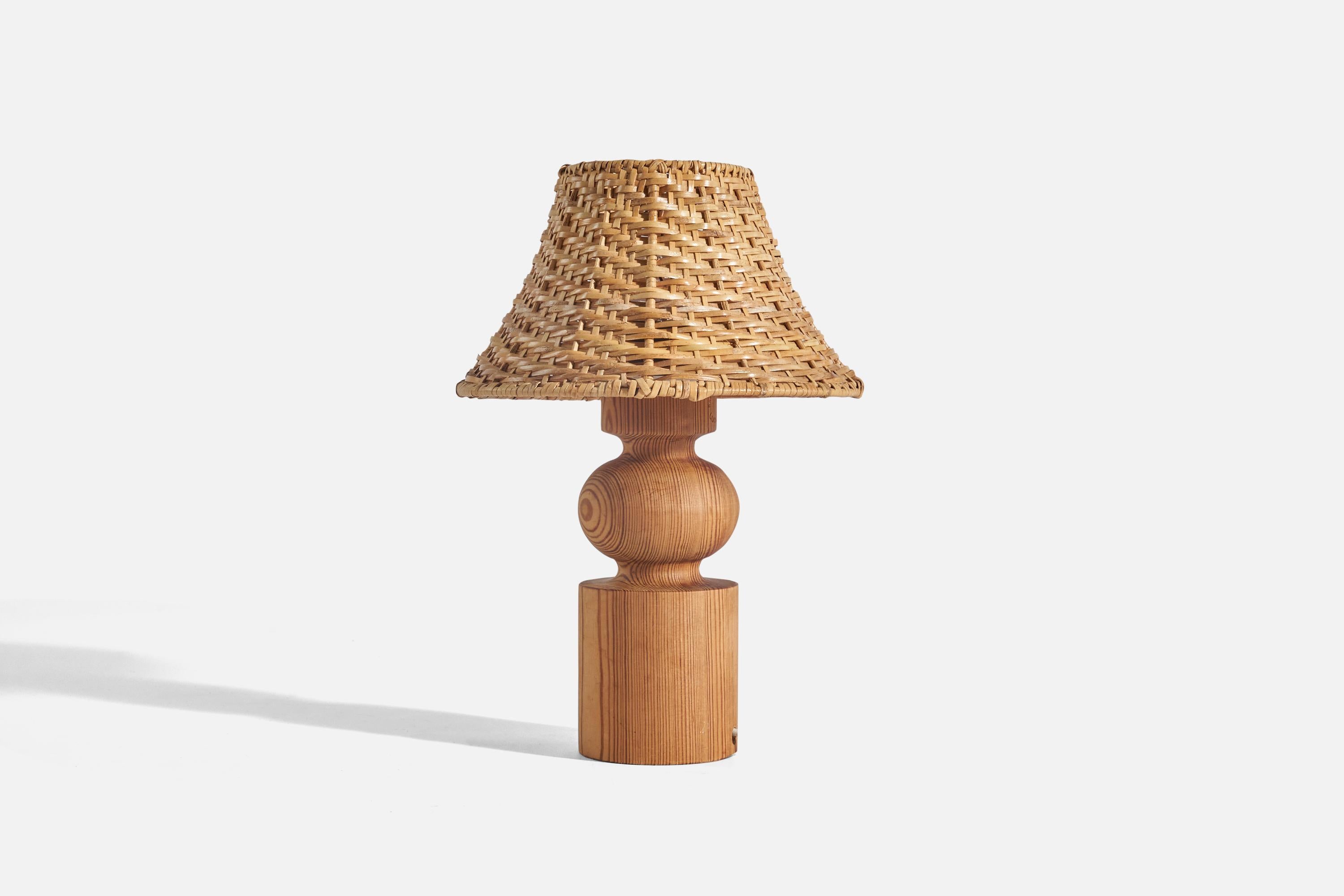 A pair of pine and rattan table lamps designed by Uno Kristiansson and produced by Luxus, Sweden, 1970s.

Sold with Lampshade(s). 
Stated dimensions refer to the Lamp(s) with the Shade(s). 

Socket takes standard E-26 medium base bulb.
There