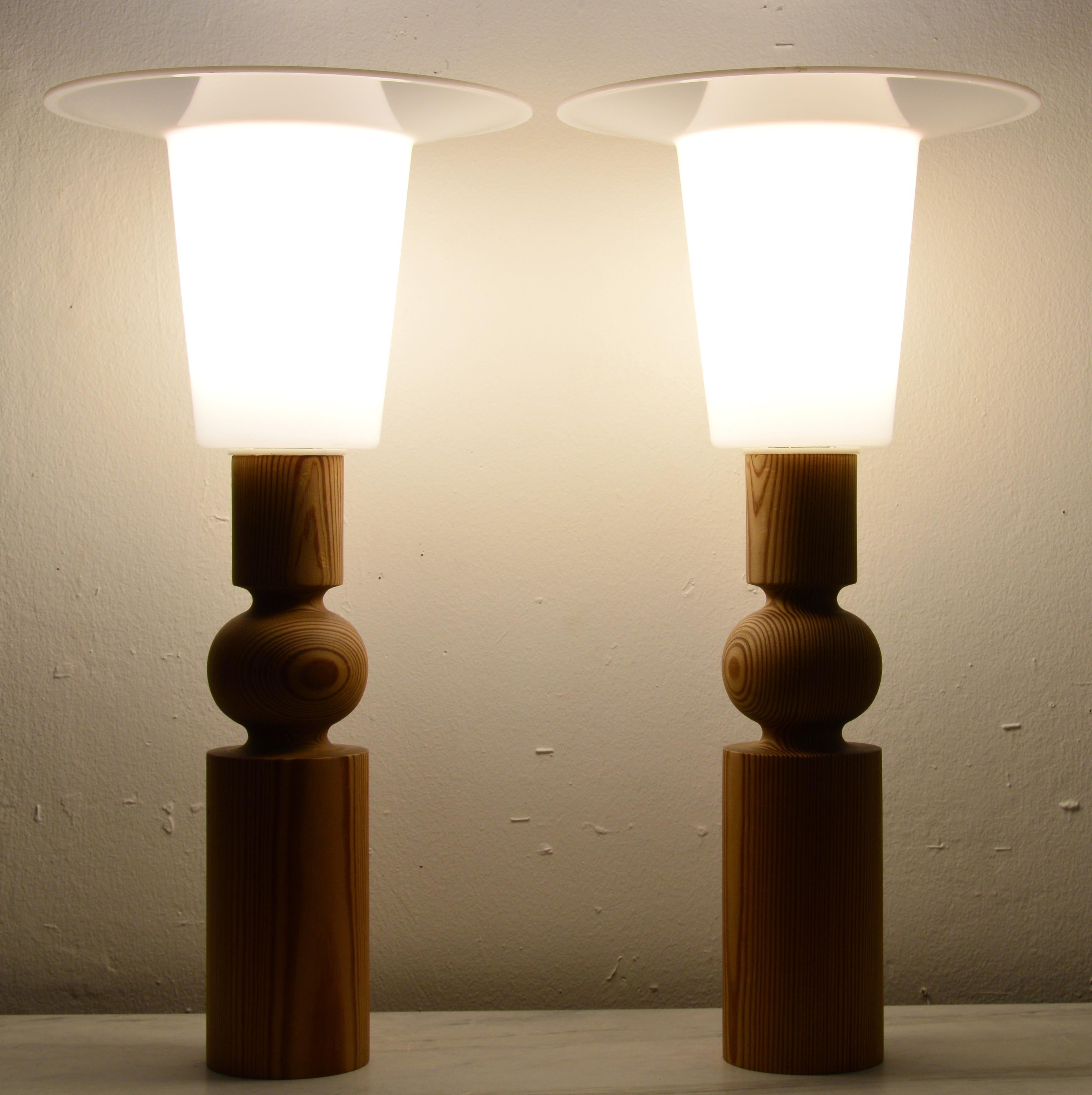 Paire de lampes de table sculpturales en pin massif conçues par Uno Kristiansson vers 1966 et fabriquées par Luxus. Le site  Le corps du modèle est en bois de pin tourné. Les lampes sont surmontées de diffuseurs en acrylique blanc. Bien que la forme