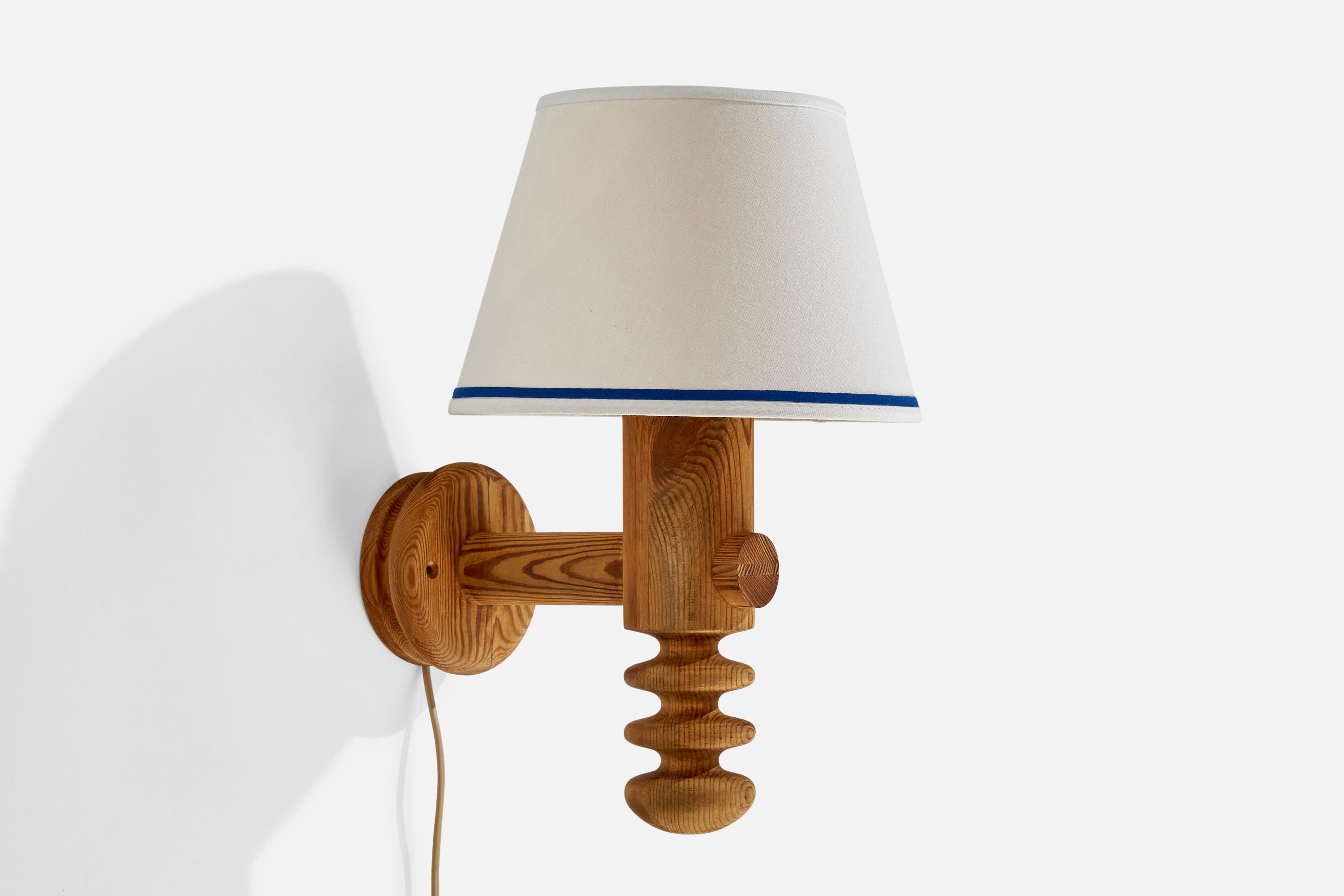 A pine and white fabric wall light designed by Uno and Östen Kristiansson and produced by Luxus, Sweden, c. 1970s.

Overall Dimensions (inches): 15.25 ” H x  10” W x  12.125“D
Back Plate Dimensions (Inches):  5” H x 5” W x 1.625” D
Bulb