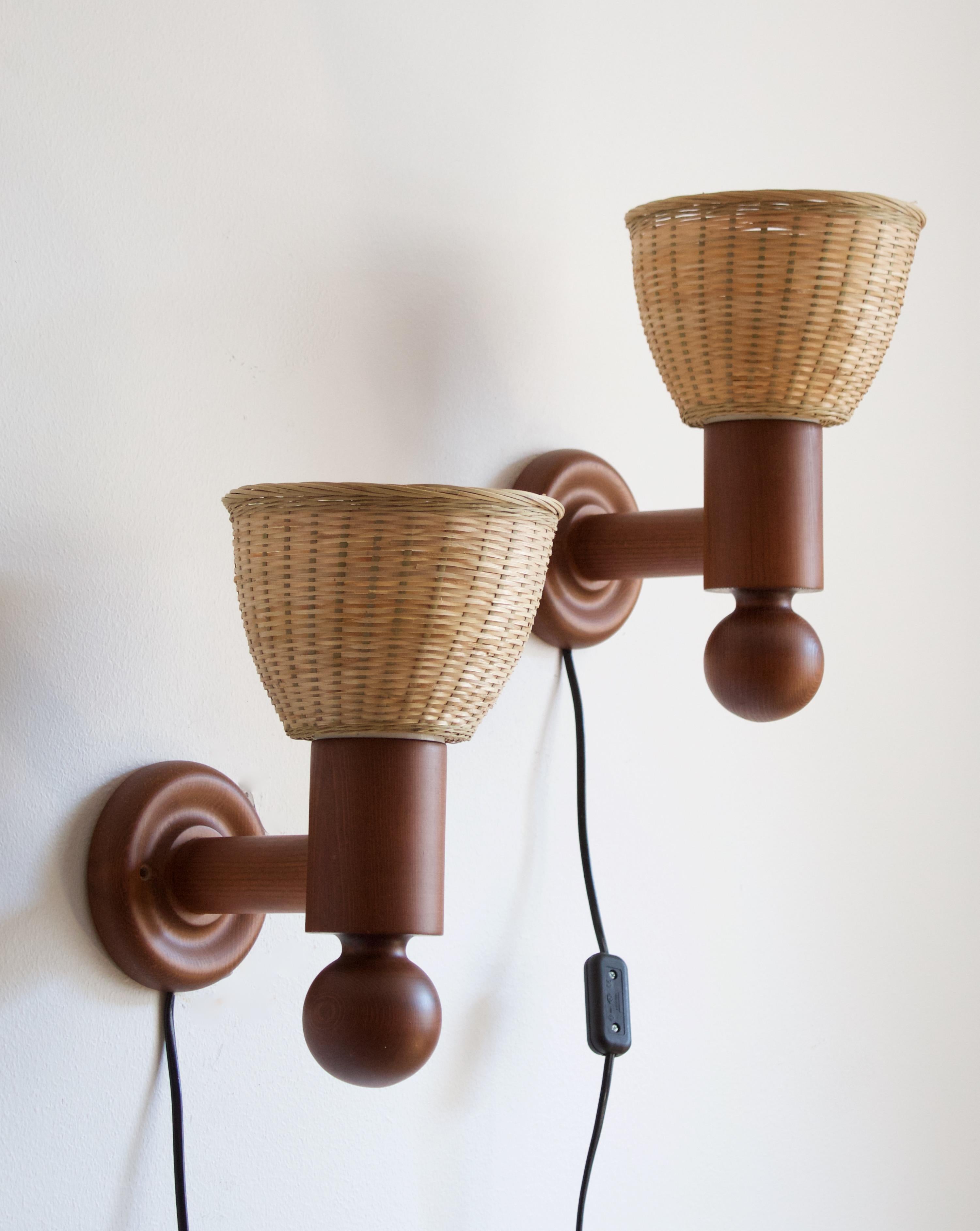 A set of sculptural solid stained pine wall lights / sconces. Designed by Uno Kristiansson, for Luxus, Sweden, 1960s. Assorted vintage rattan lampshades.

Other designers of the period include Axel Einar Hjorth, Roland Wilhelmsson, Charlotte