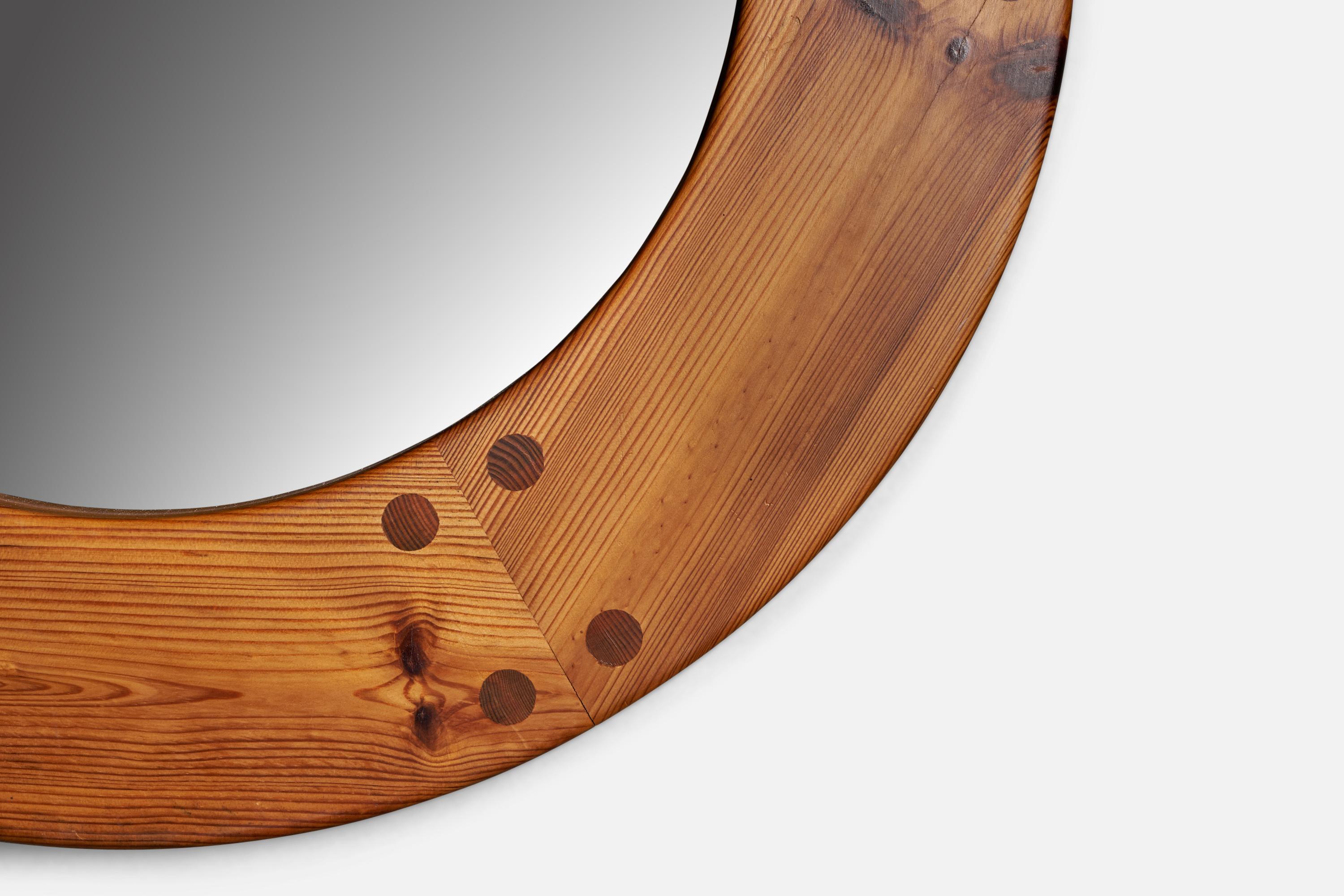 A round pine wall mirror designed by Uno Kristiansson and produced by Luxus, Vittsjö, Sweden, 1970s.