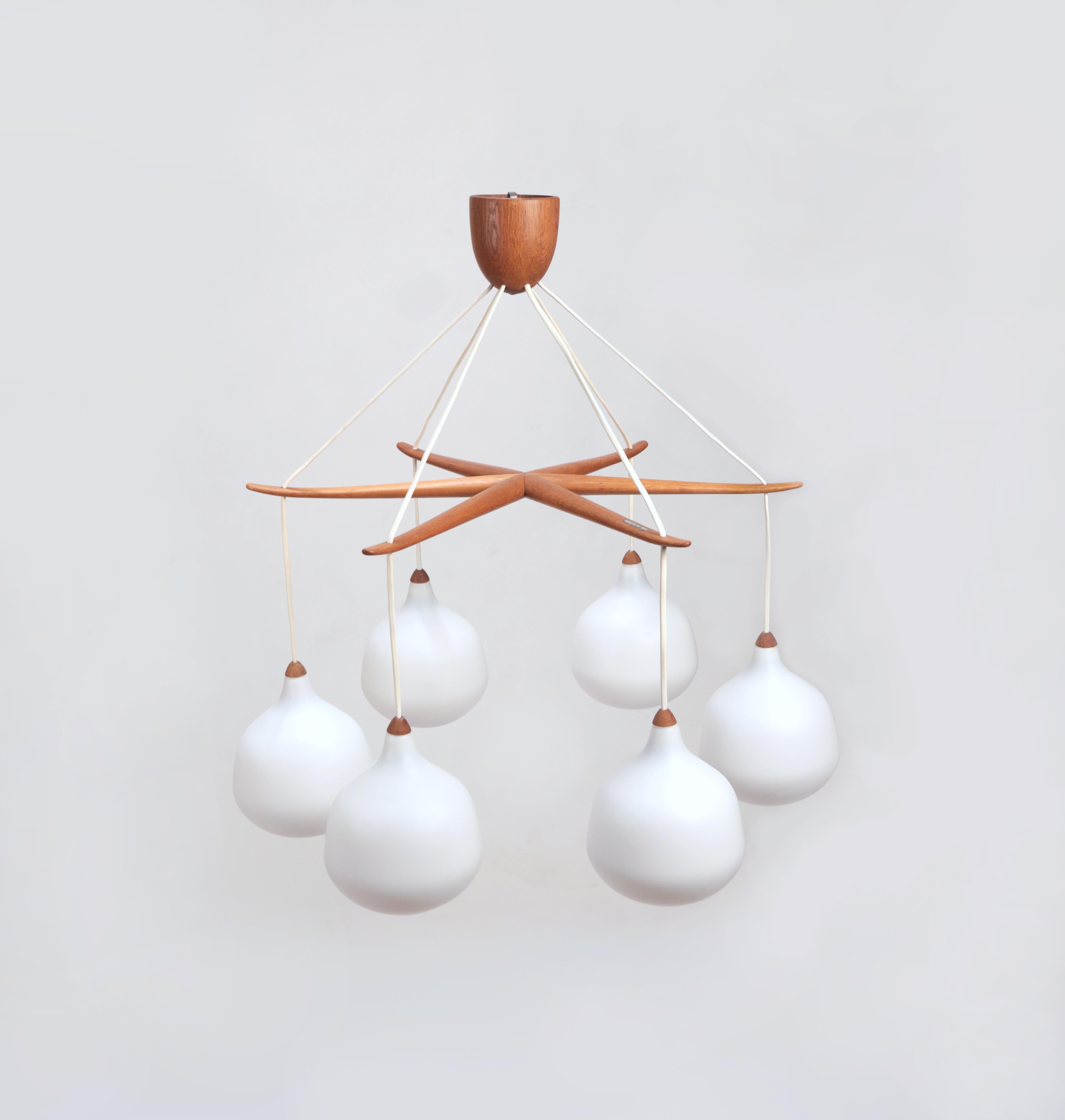 Uno & Östen Kristiansson 6 point star chandelier model 529 Luxus, Sweden, 1950s

Made of oak and opaline glass this chandelier is in excellent condition. No chips or scratched in the glass and the makers mark is clear on the top of one of the