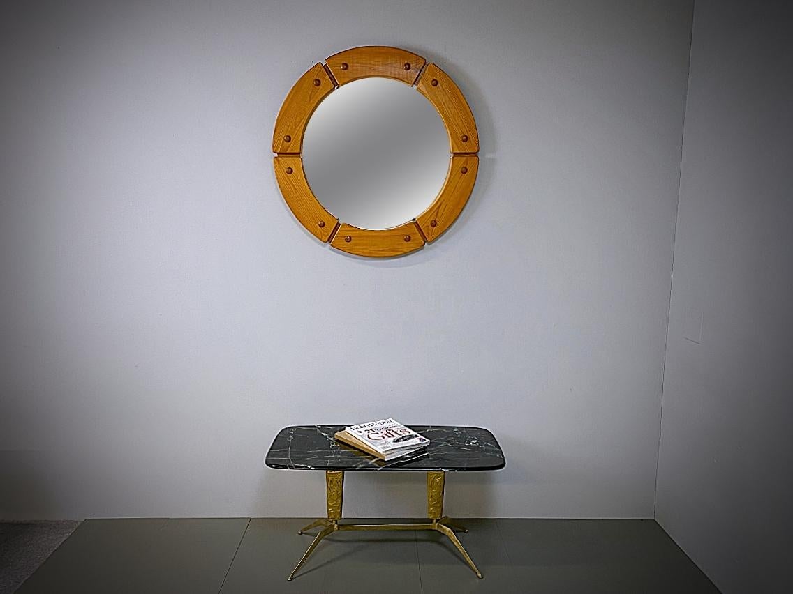 Sculptural round mirror with solid pine wood frame made by Fröseke AB Nybofabriken from the 1960s, Sweden. Massive frame with decorative wooden nails. Stamped: Made in Sweden. The mirror is in very good condition. We love to create the illusion of