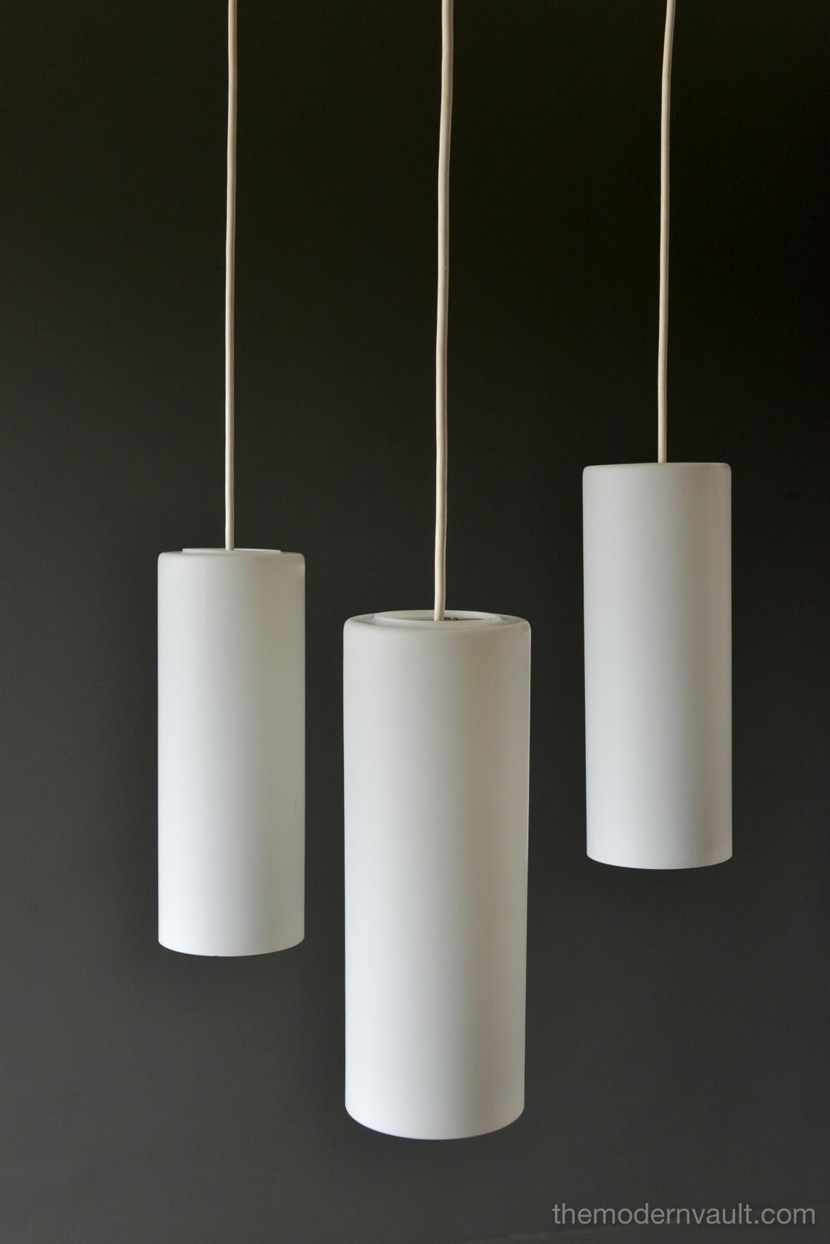 Uno & Östen Kristiansson for Luxus frosted triple cylinder pendant, circa 1960. Swedish Modern Uno & Osten Kristiansson for Luxus of Sweden. Translucent frosted glass cylinder and hanging lamps. Featuring three opaline glass shades, that hang at