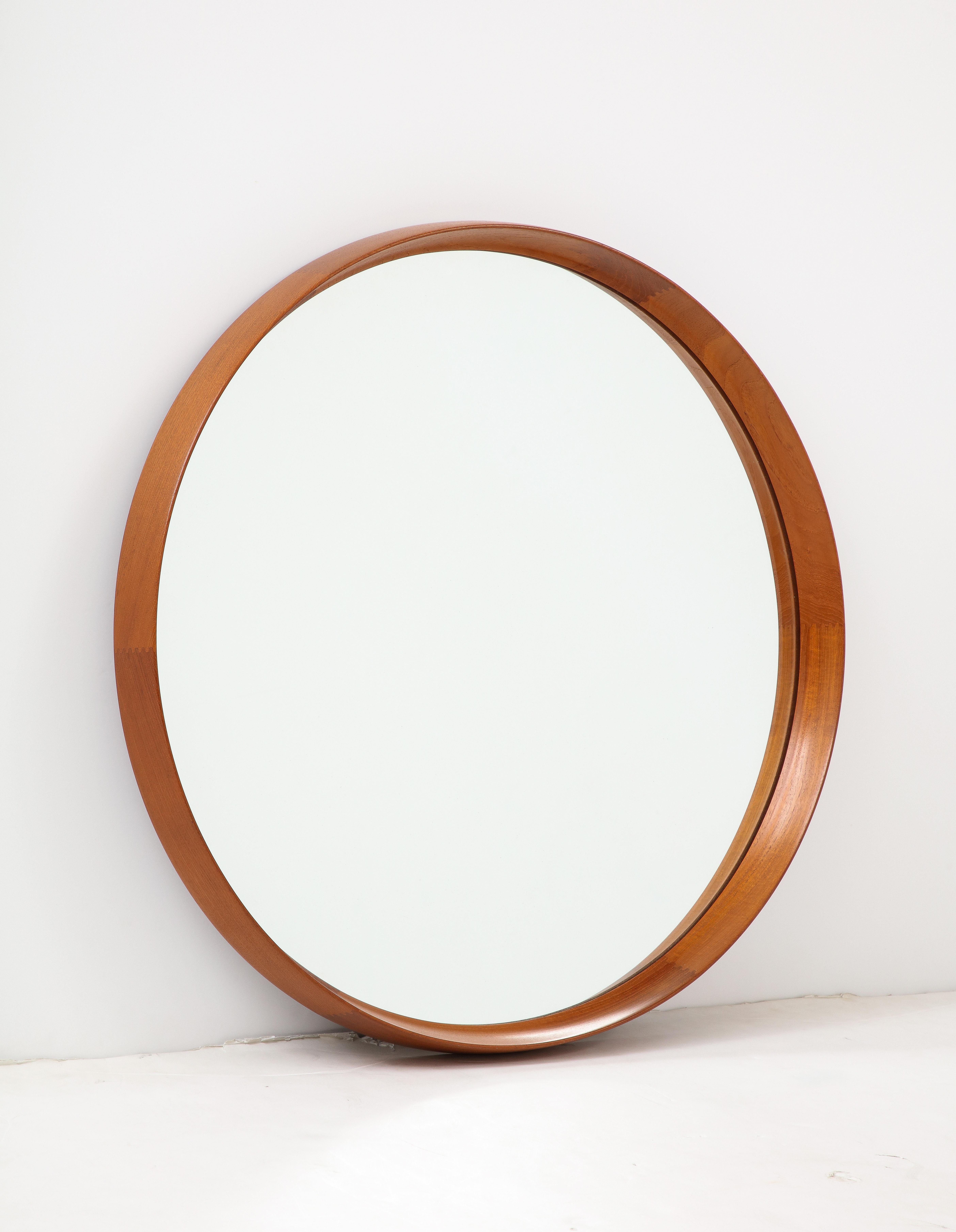 Scandinavian round teak wall mirror by Uno & Osten Kristiansson for Luxus, Sweden. High quality design and execution with finger joint construction in a sculpted frame. Ready to install.