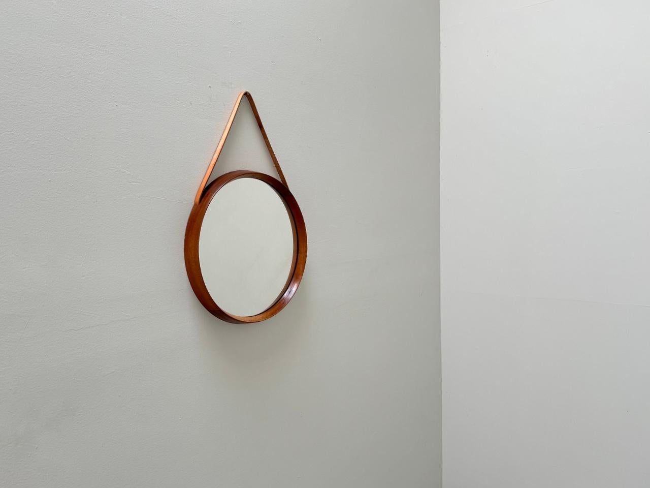 Magnifique miroir rond conçu par Uno & Östen Kristiansson pour Luxus Vittsjö Möbelfabrik dans les années 1960, Suède. Cadre massif en bois de teck avec sangle de suspension décorative en cuir intégrée. Le miroir est en très bon état. Le miroir est