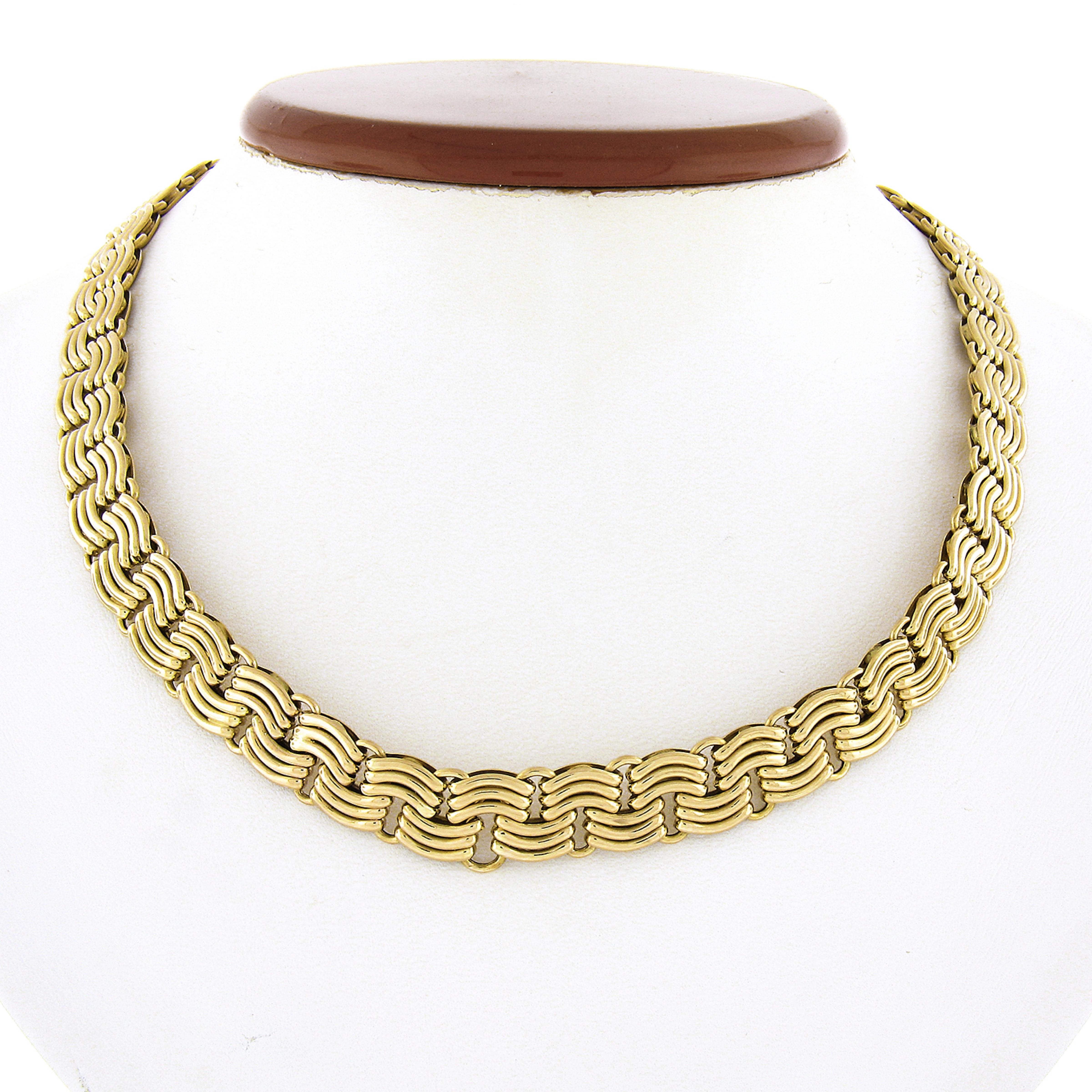 This gorgeous chain necklace was crafted in solid 14k yellow gold by UNOAERRE Italy. It features a unique and fancy polished braided flat link design. The link have a beautiful hallowed design which gives the necklace its rich and bold look. It is